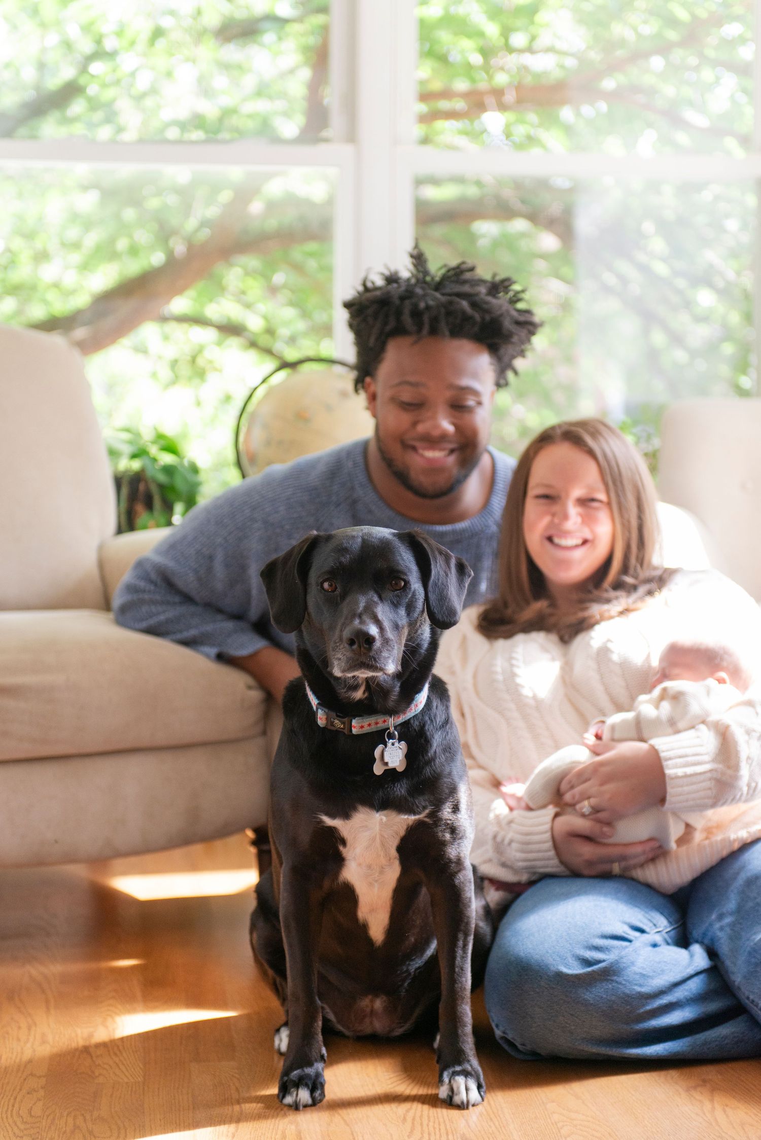 Family holding newborn during lifestyle session in their home