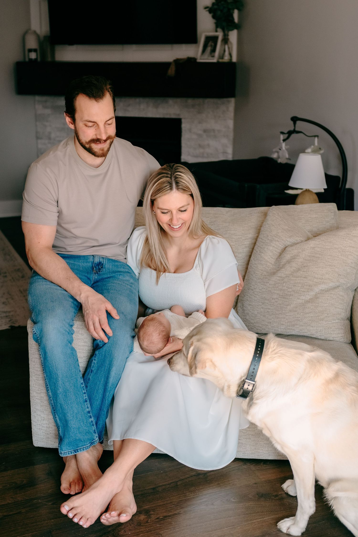 Family smiling at dog during intimate newborn session
