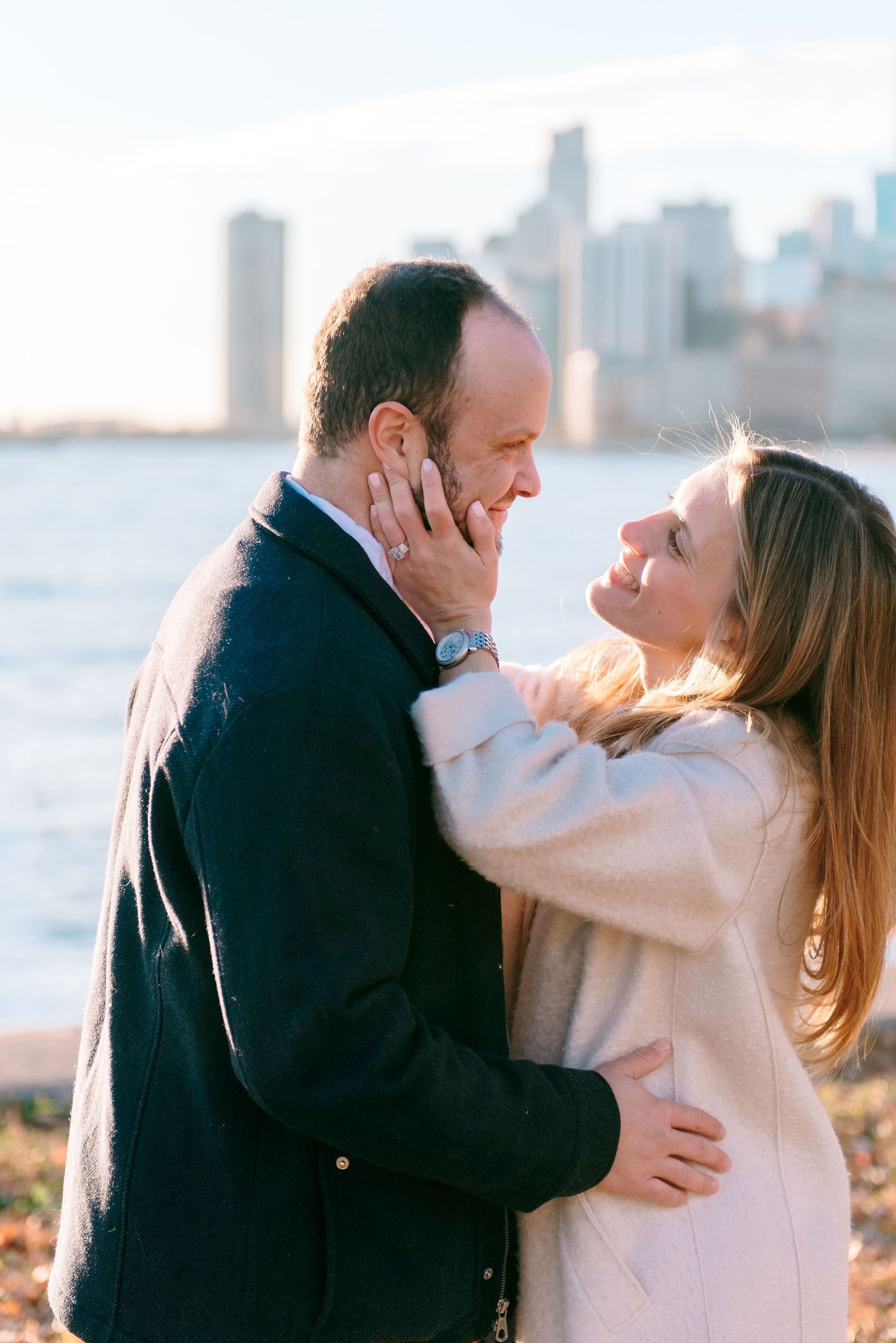 Engaged couple smiling and laughing on Chicago lakefront during photo session