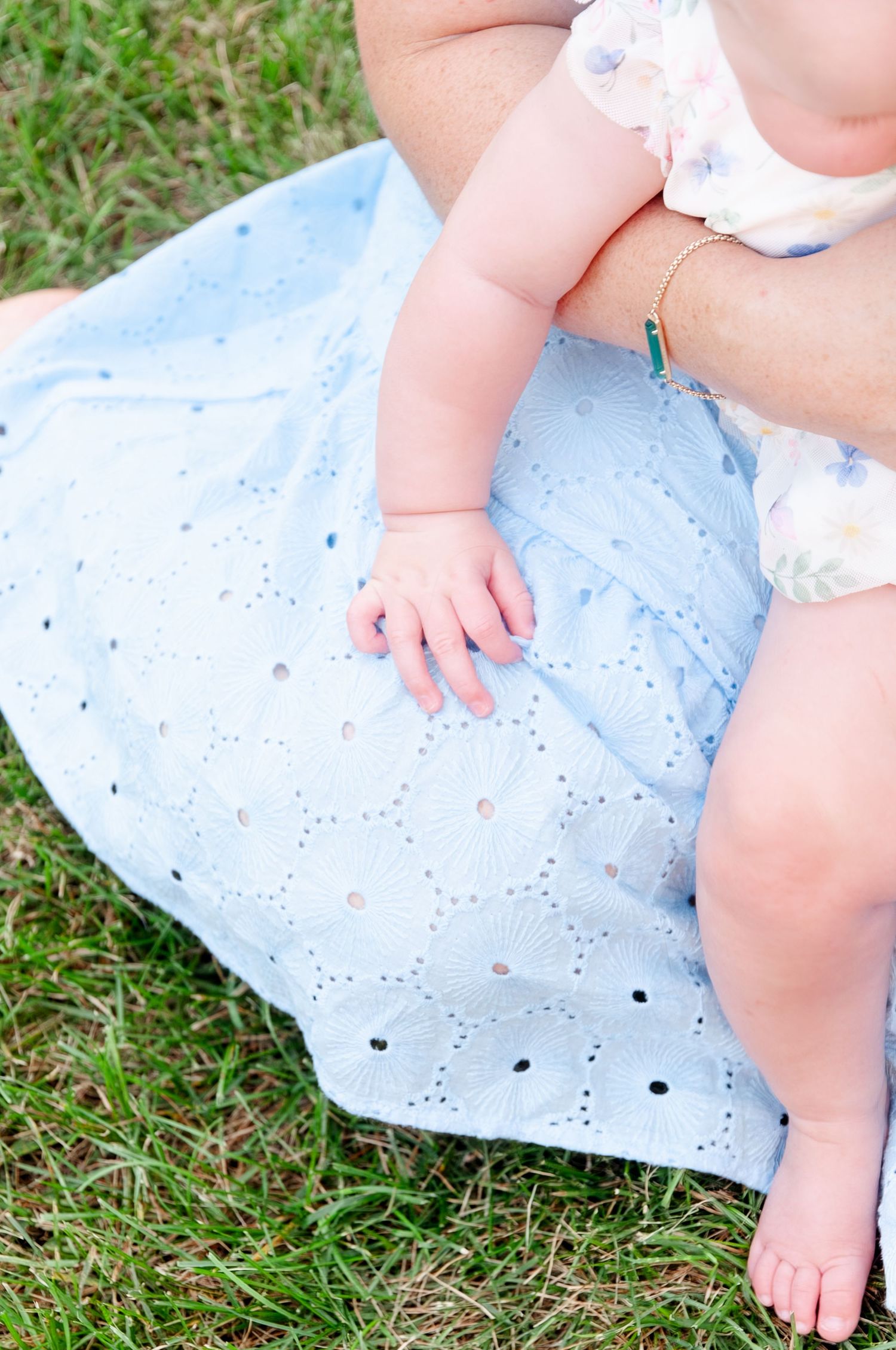 Closeup of child's hands and feet during maternity session in park