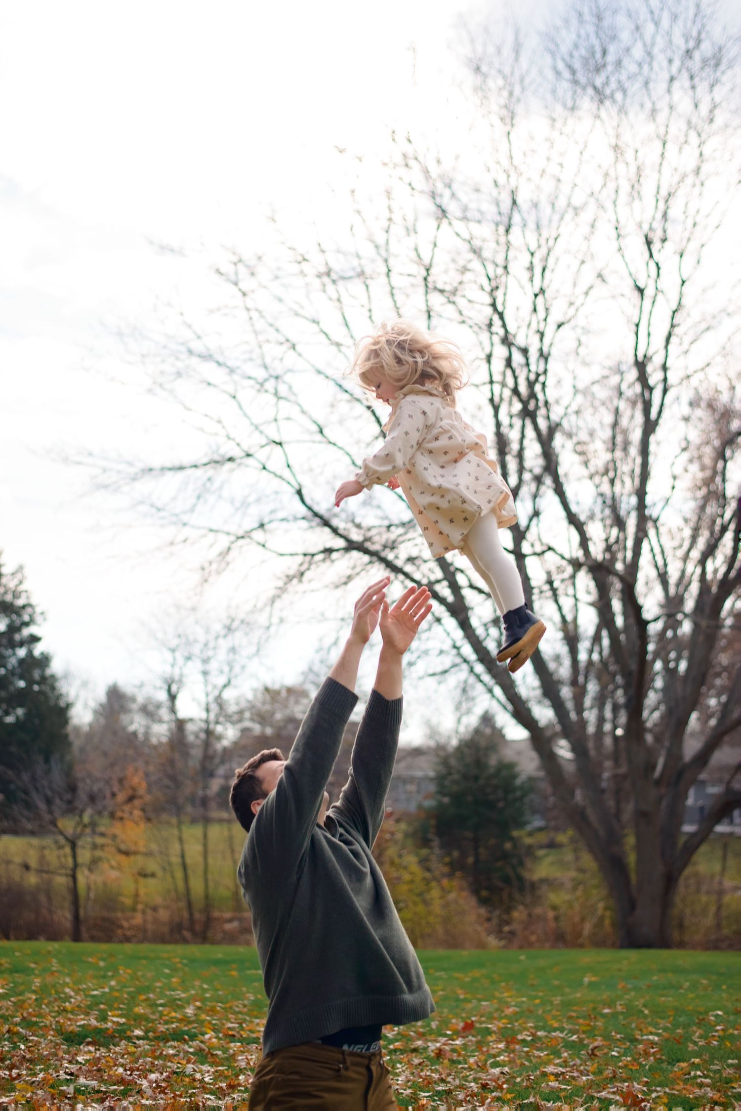 Dad throwing up daughter into air during photography session