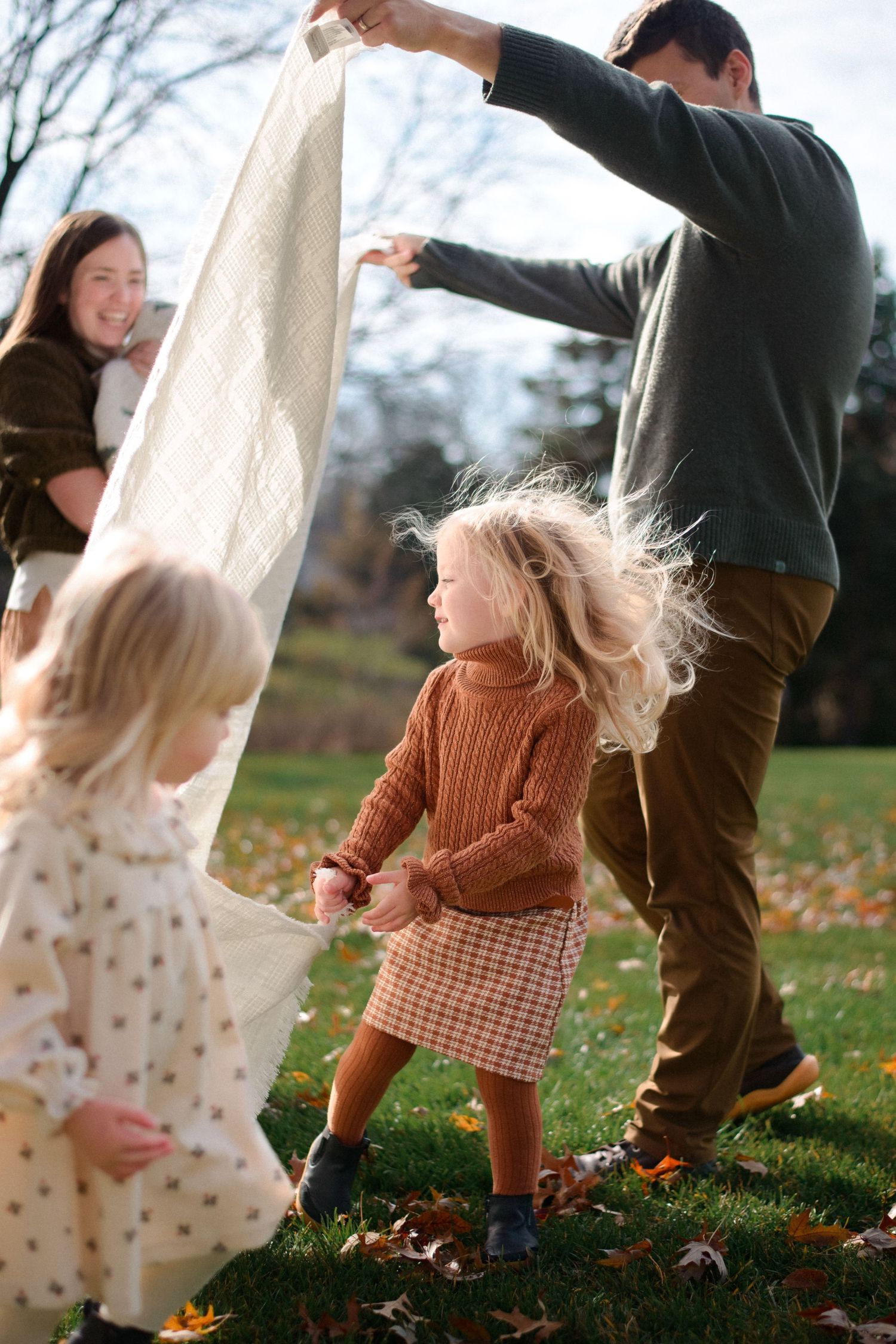 Daughters playing under blanket during fun, informal family shoot