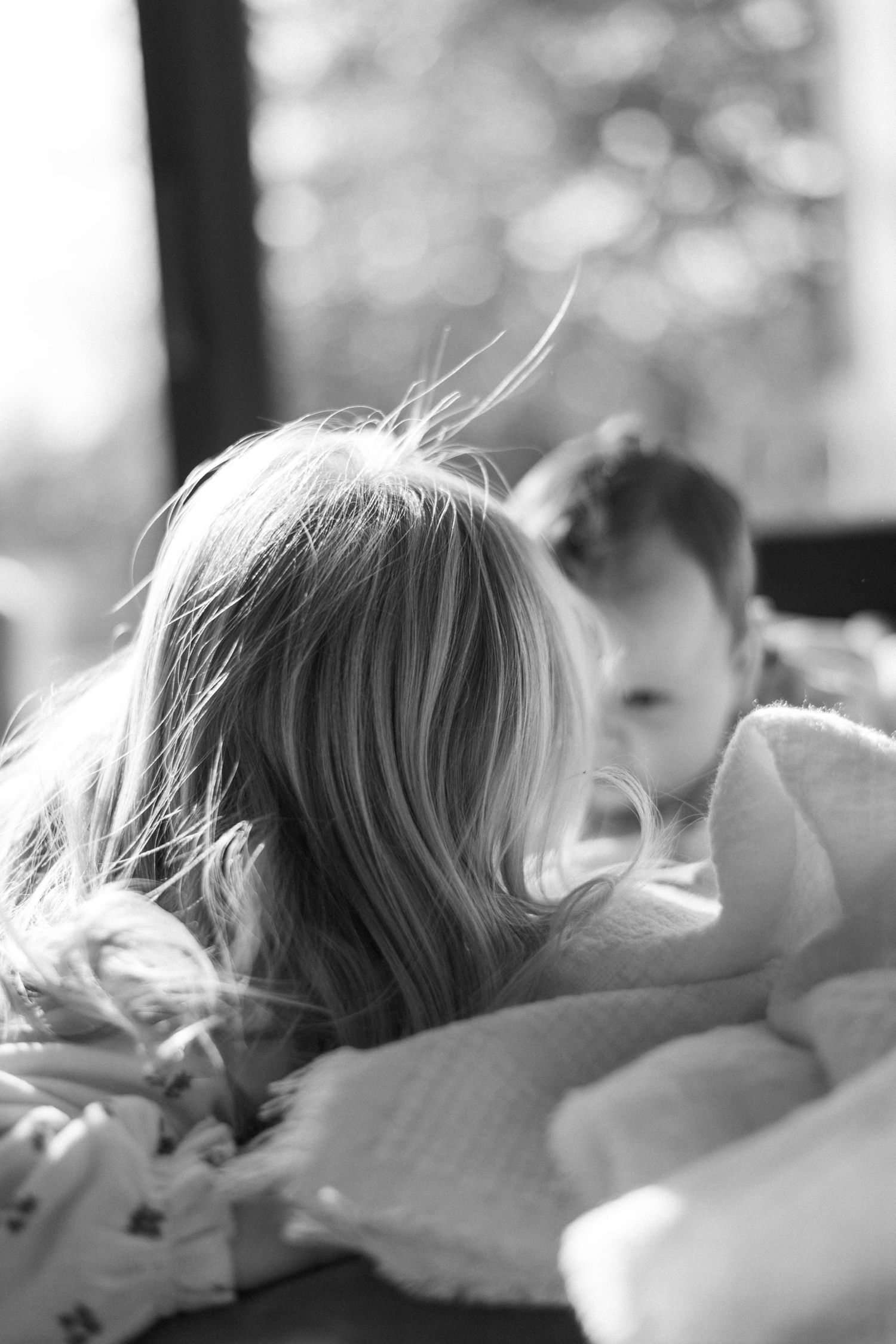 Sibling kisses baby while playing during photoshoot