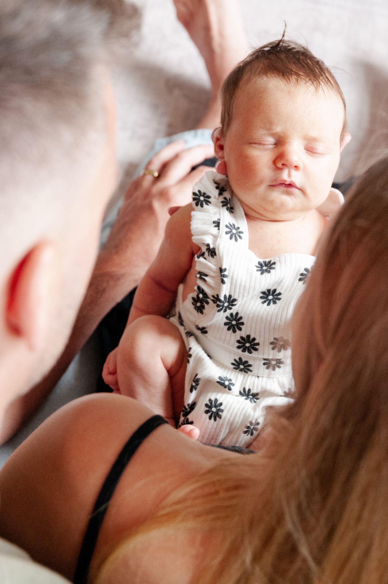 Father and mother holding newborn during in home photo session