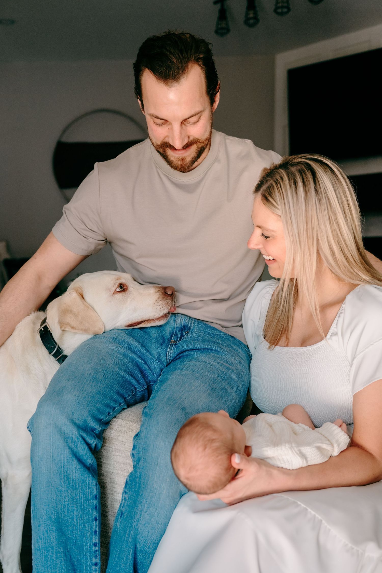 Father hugging mother and dog during in-home family session