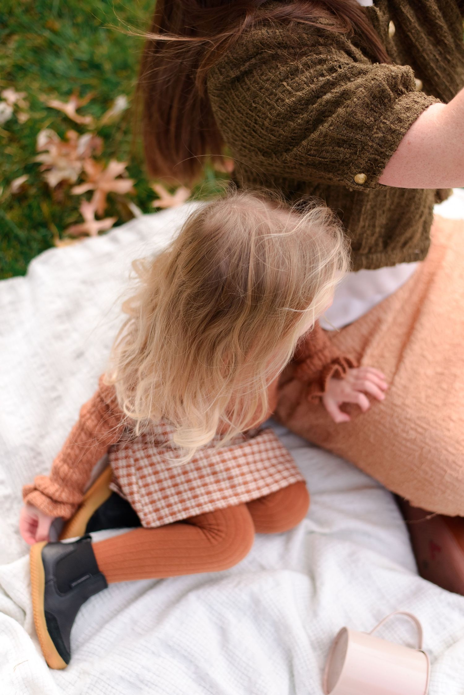 Daughter and mother sharing a quiet moment during cozy fall session