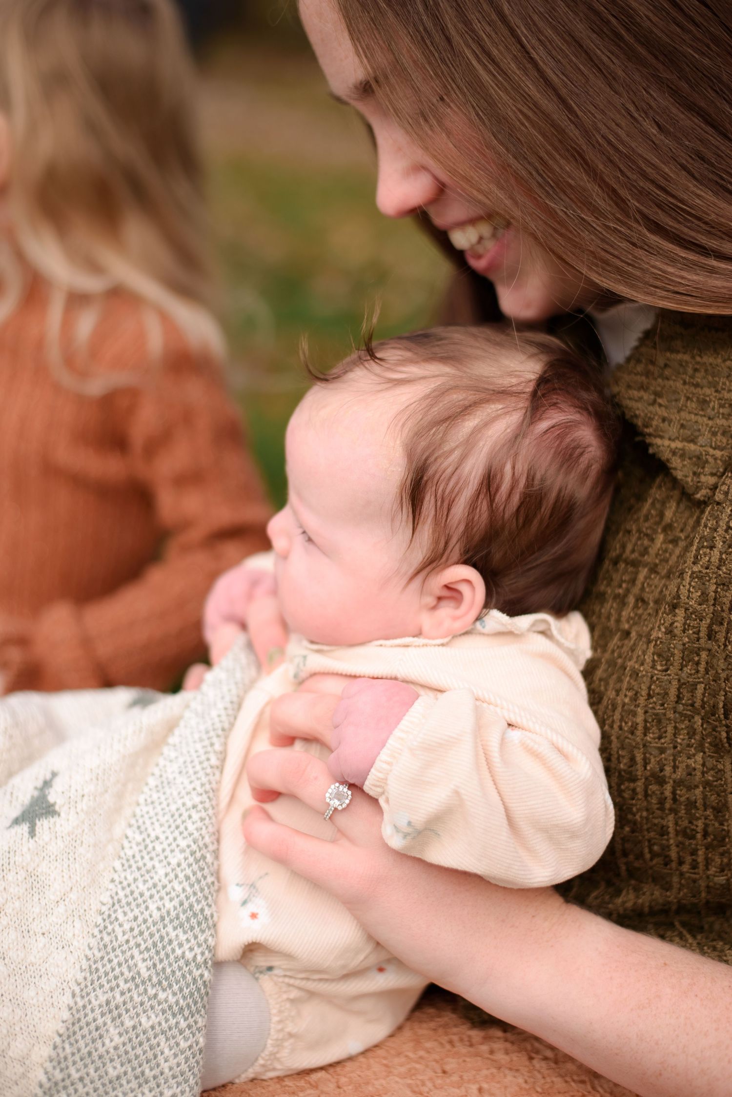 Mother smiling down at baby during family session