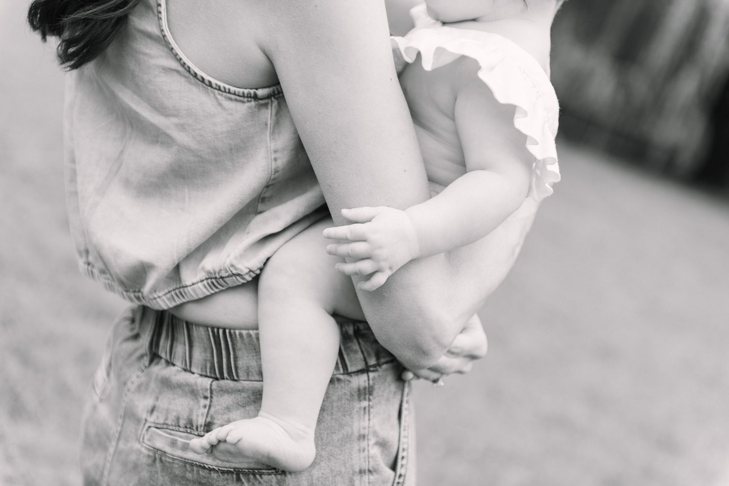 A closeup shot of a mother supporting a baby against her chest during fall picnic photoshoot