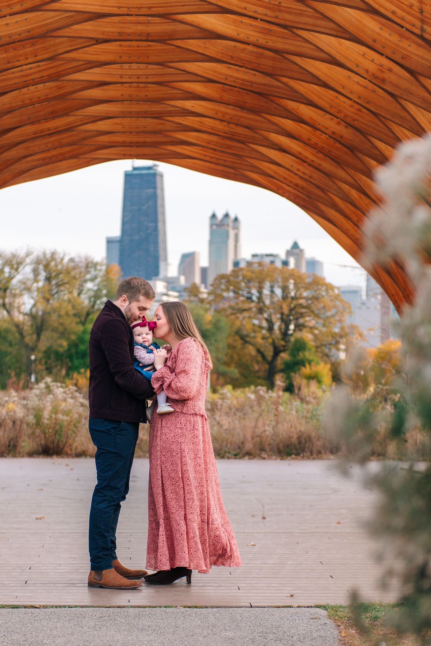 Parents kissing newborn during intimate family portrait session in downtown Lincoln Park