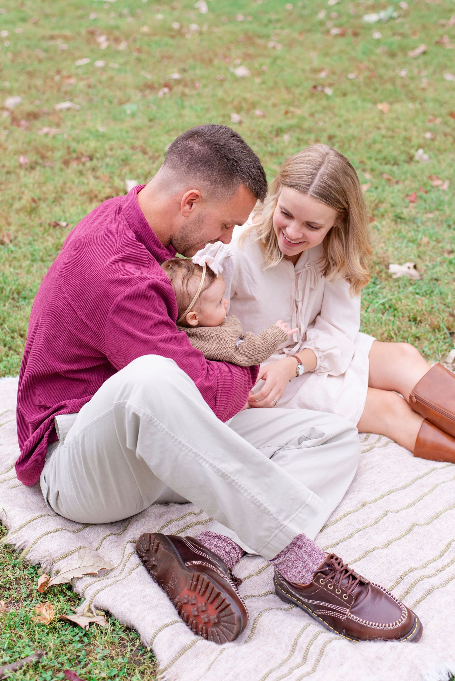 Young family holding a small toddler on a fall afternoon shoot in Lincoln Park