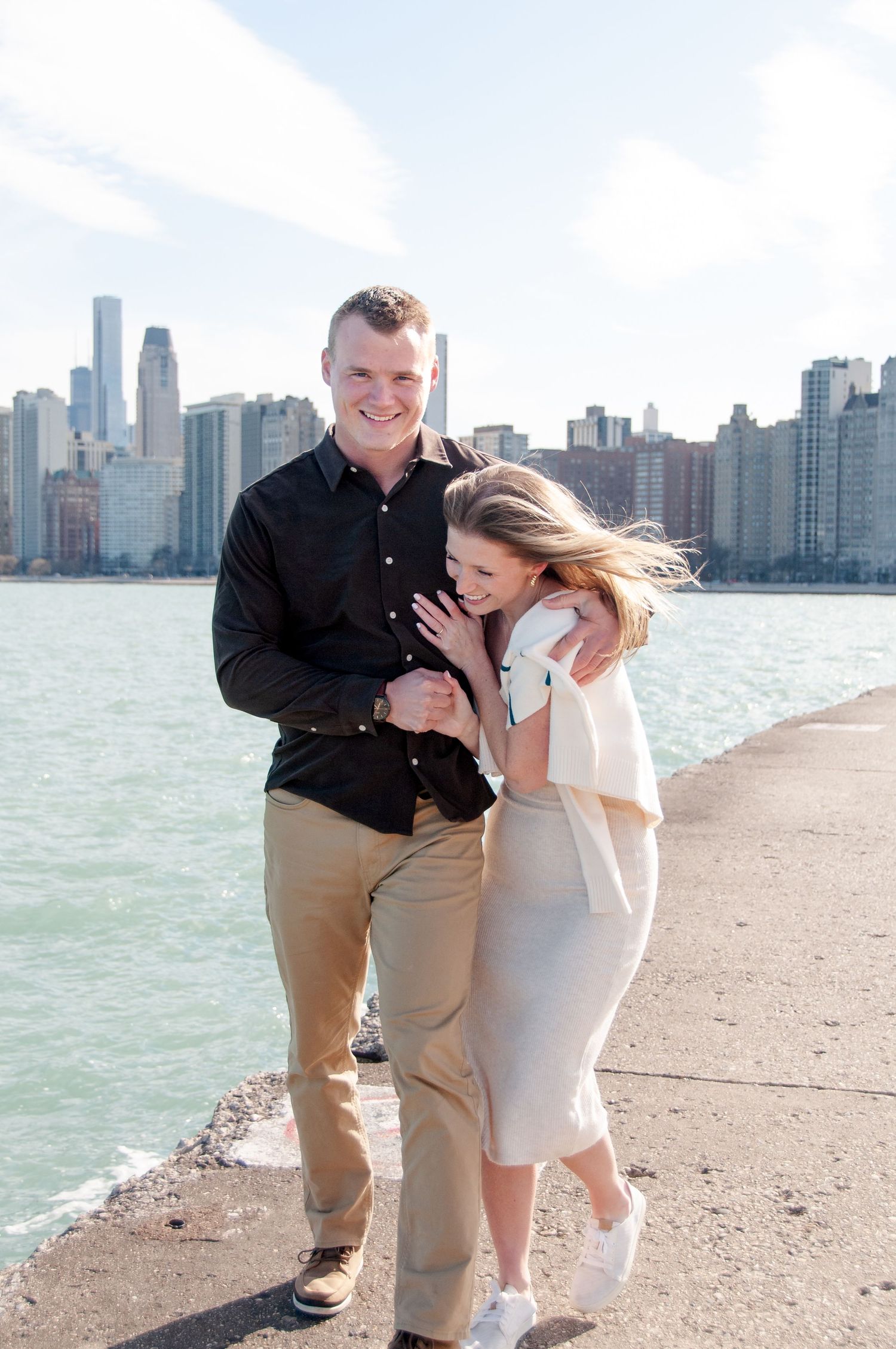 Couple smiling and laughing along lakefront in downtown Chicago