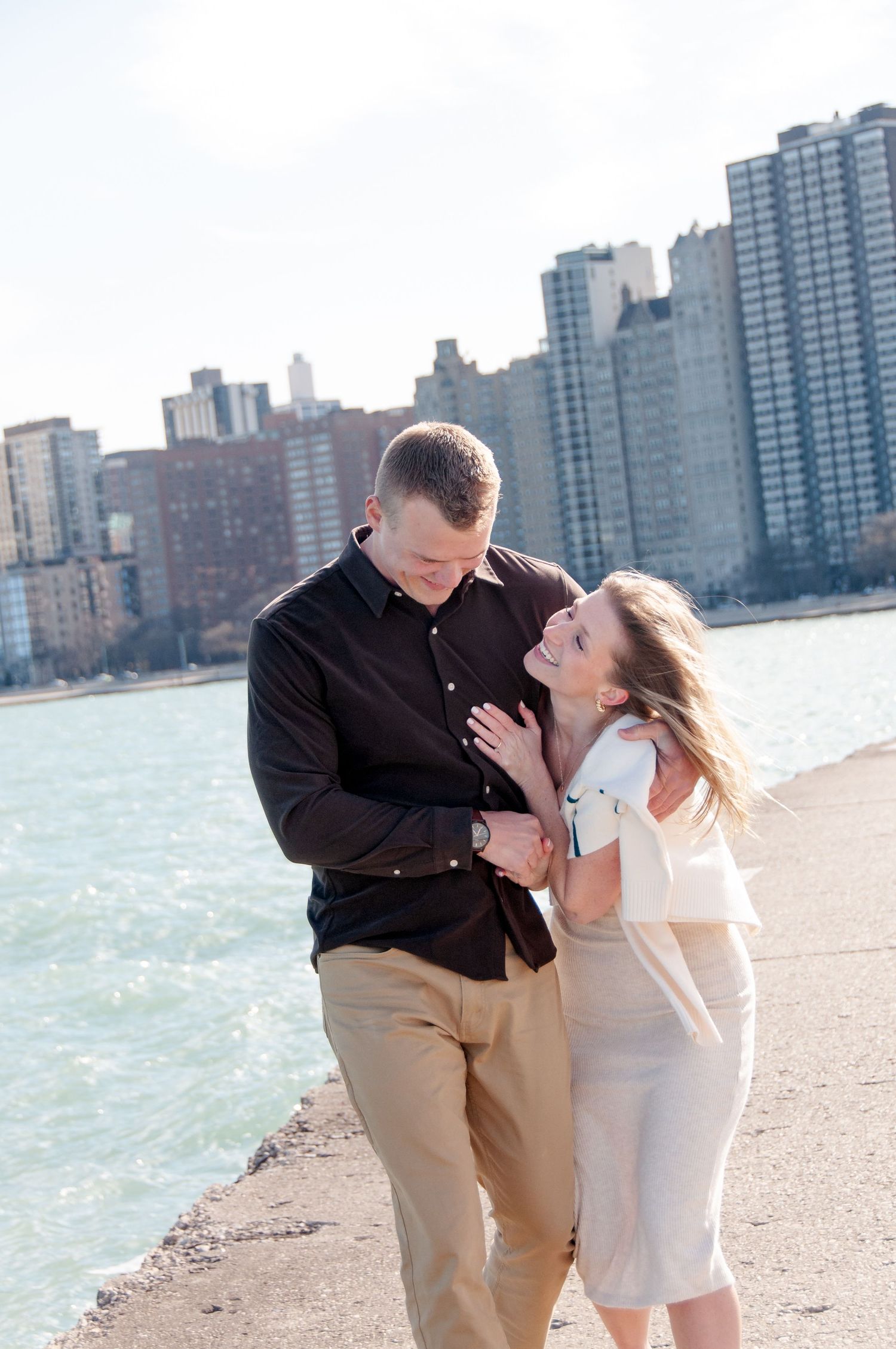 Engaged couple hugging and laughing on Chicago lakefront