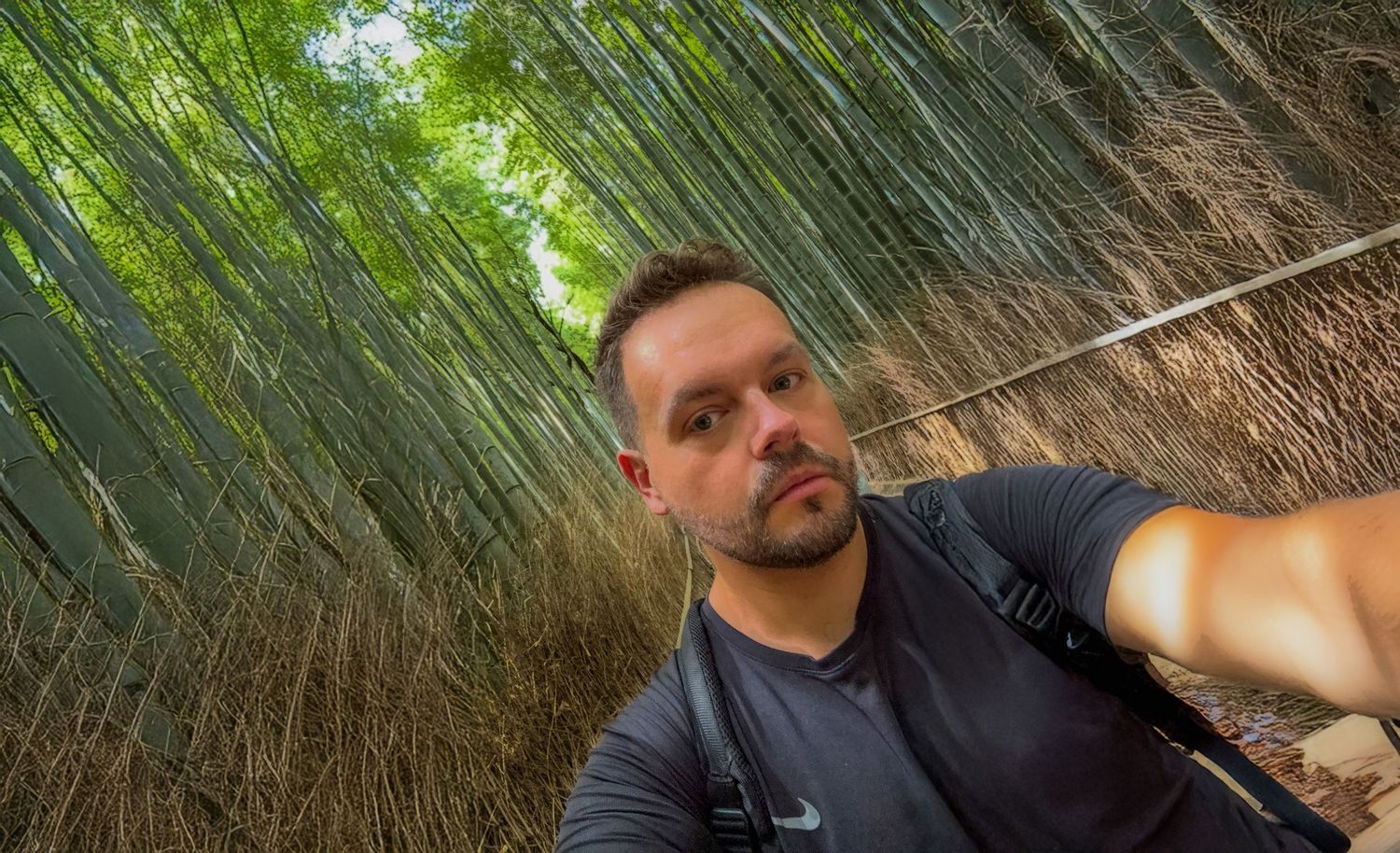 Daniel - selfie. Japan, Kyoto.  Outdoors with bamboo trees creating a natural green backdrop.