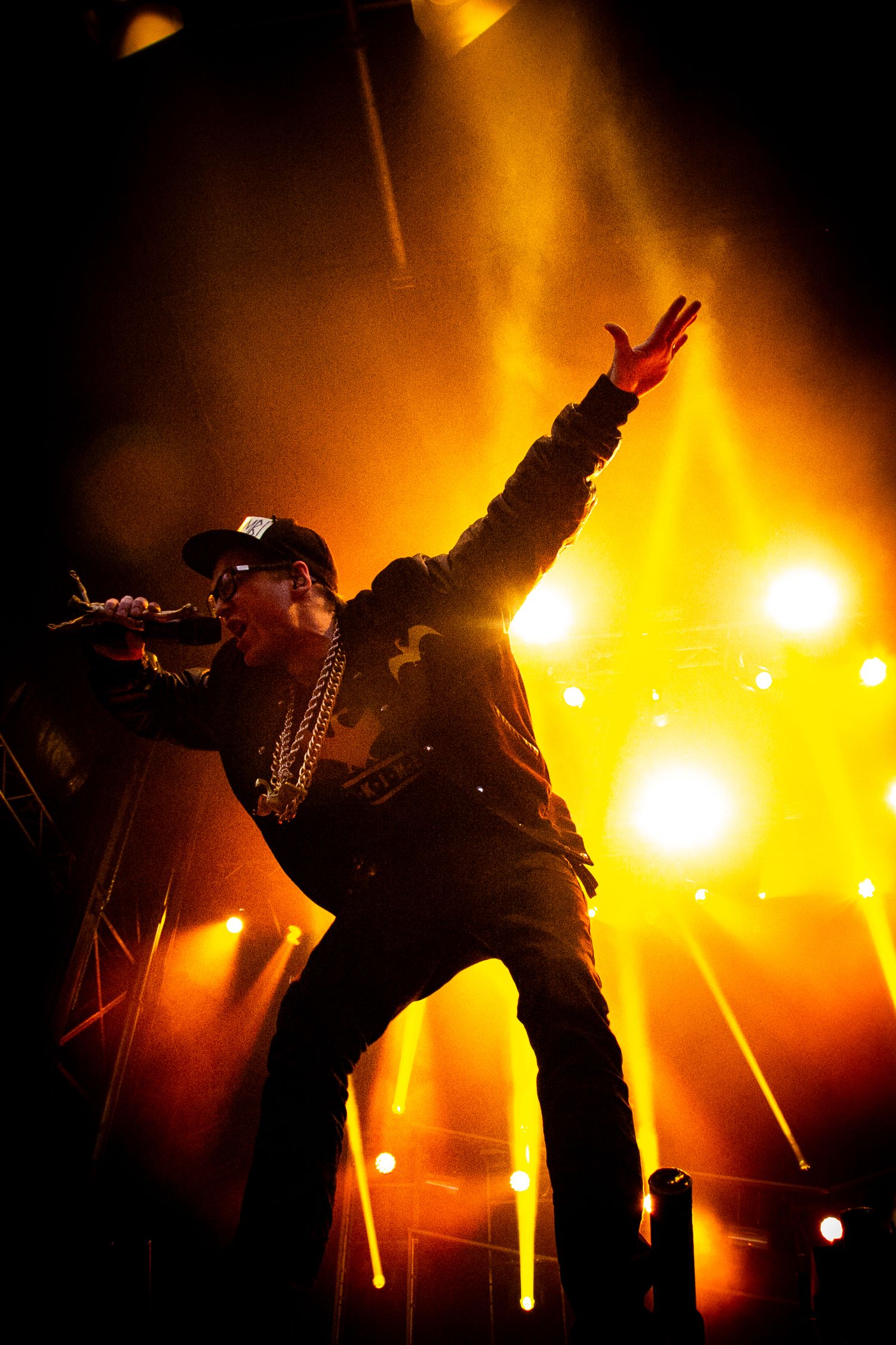 Silhouettes of performers on stage with dramatic orange backlighting creating dynamic poses.