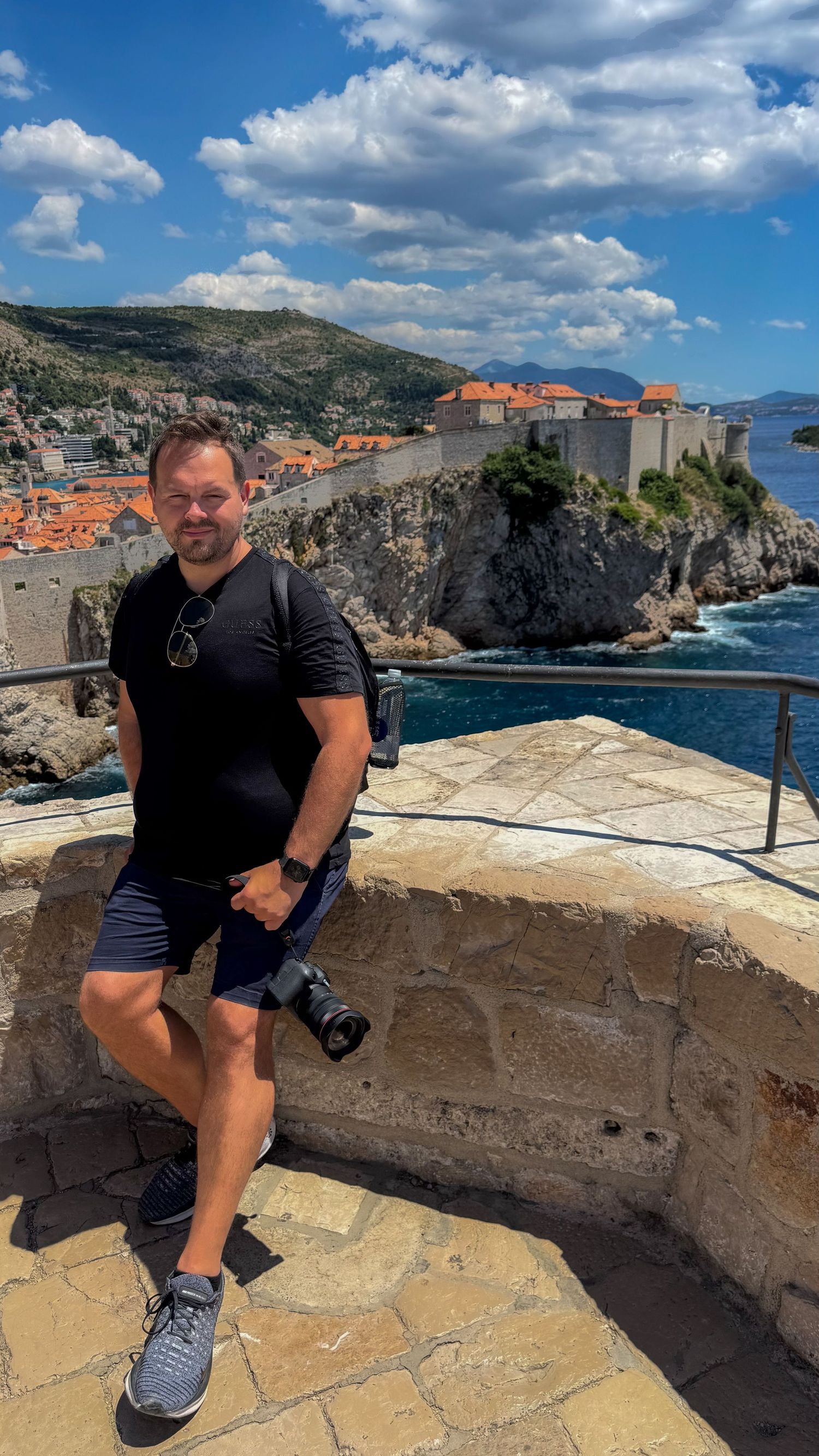 Daniel - selfie. Daniel overlooks the historic walled city of Dubrovnik and Adriatic Sea from scenic viewpoint on sunny summer day.