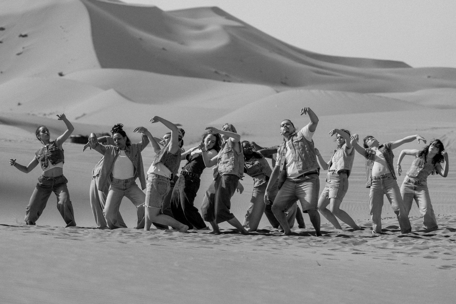 Chorégraphie de groupe dans les dunes à Merzouga, photo artistique en noir et blanc, danse contemporaine.