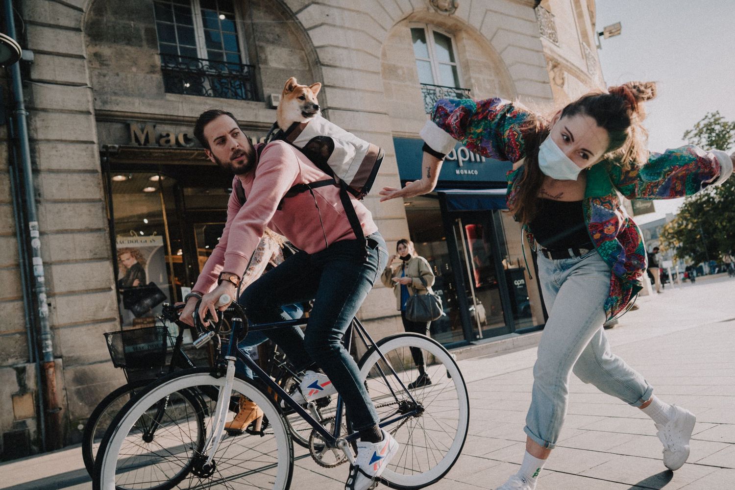 Photo urbaine dynamique d’une danseuse et d’un cycliste en interaction, ambiance street.
