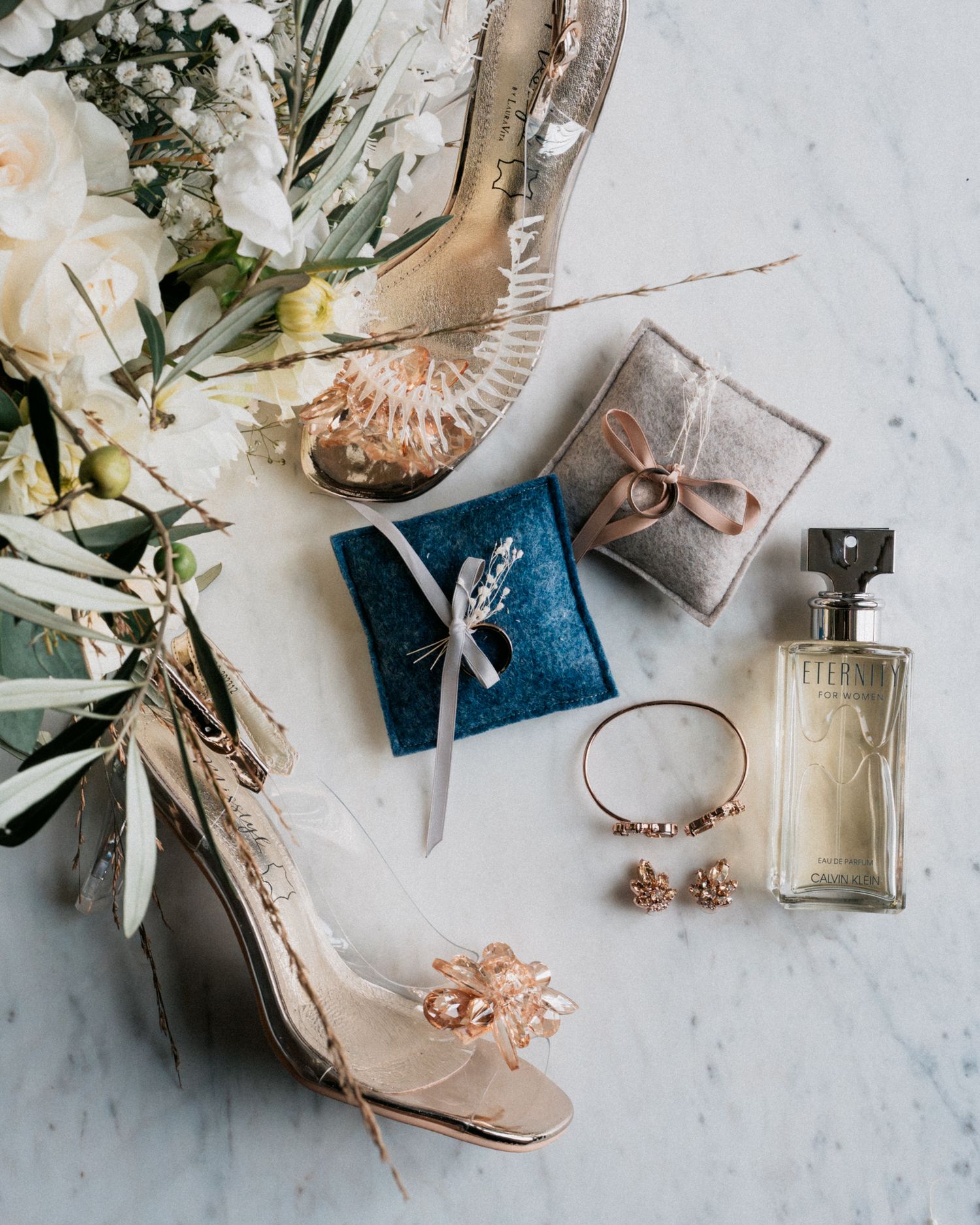 Flatlay d’un mariage : détails élégants des alliances, chaussures et bouquet, capturés avec finesse