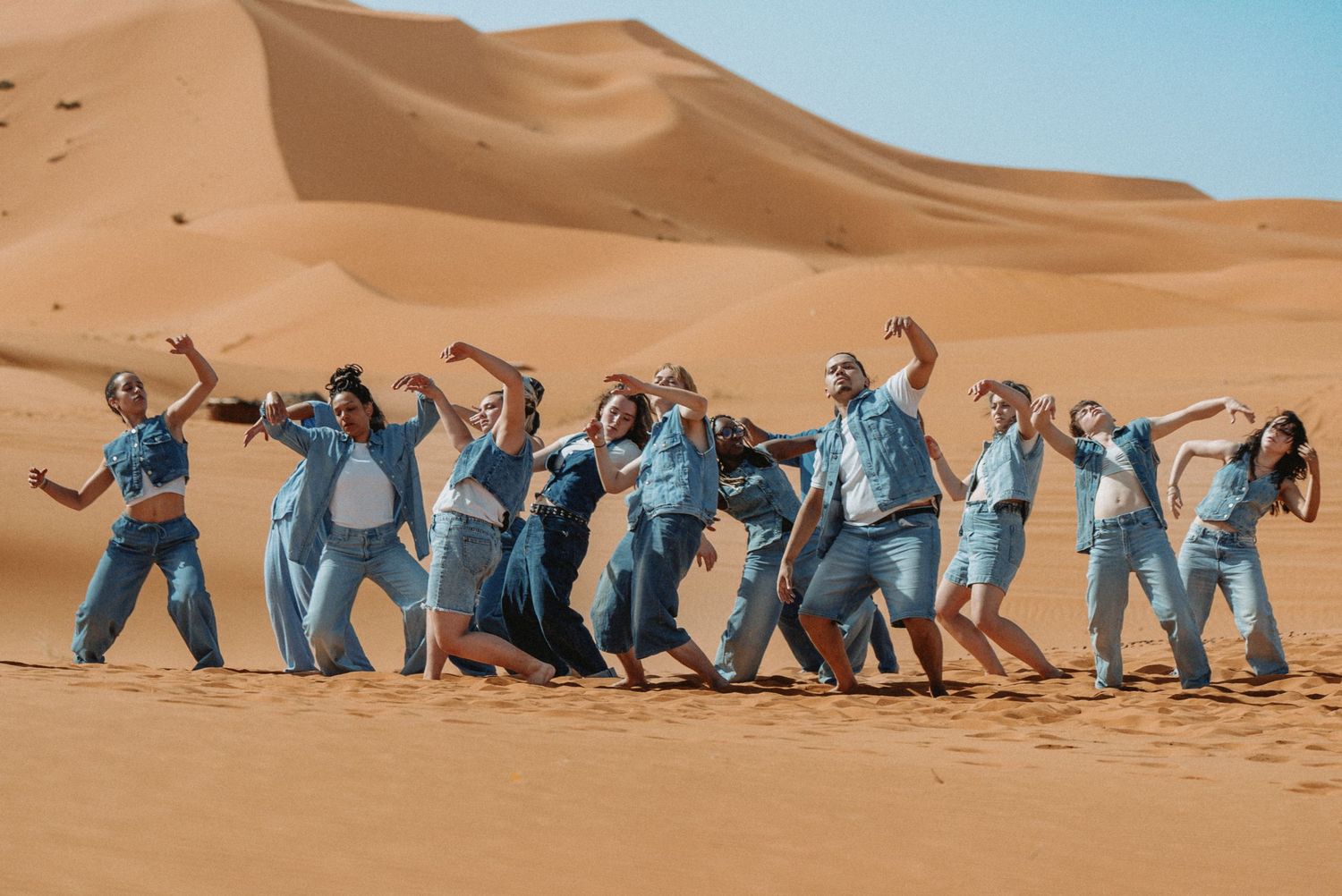 Photo artistique de groupe en tenue bleue marchant dans le désert, projet chorégraphique.