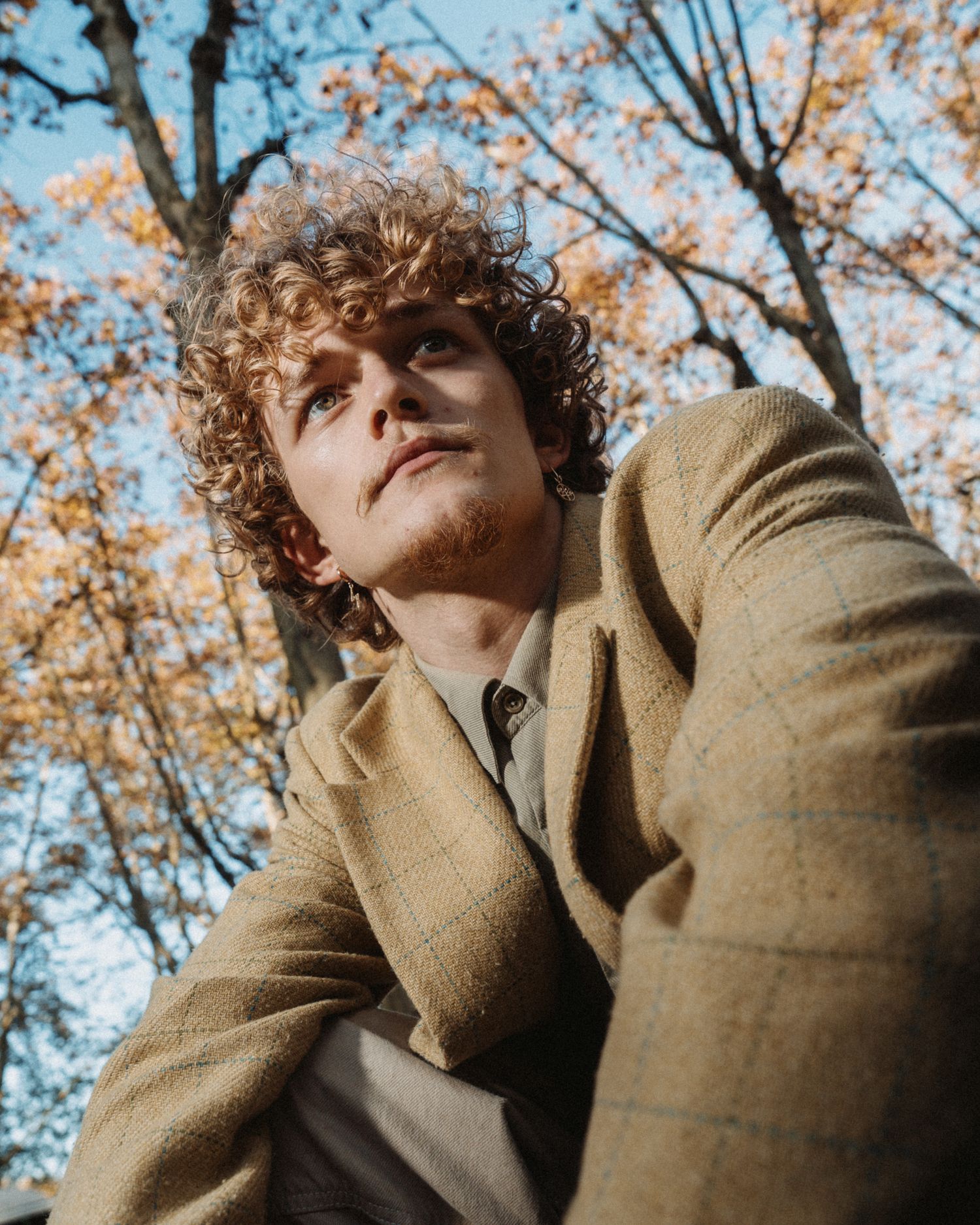 Portrait mode homme en extérieur, lumière naturelle, ambiance automnale et vintage.
