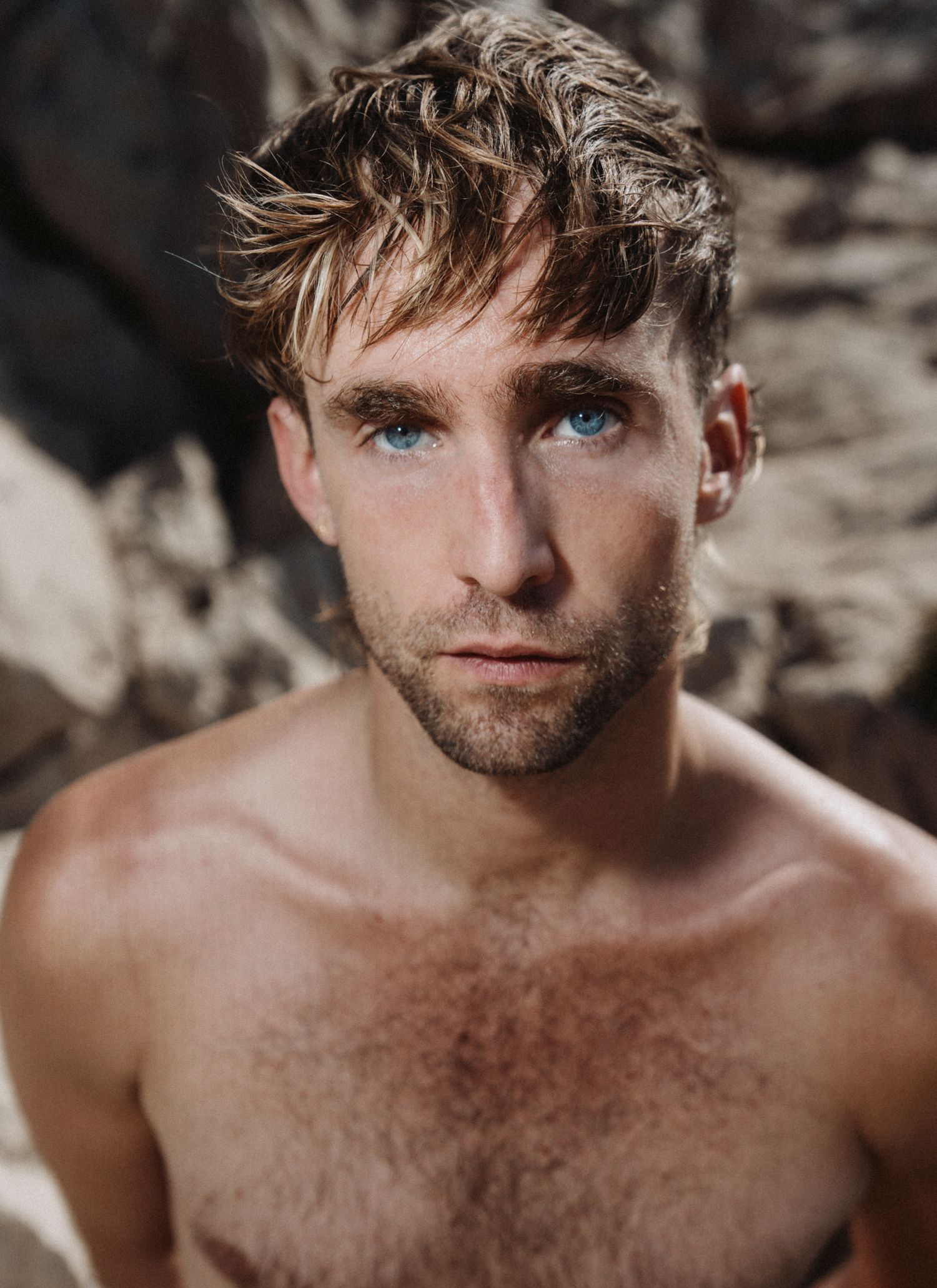 Portrait masculin naturel, regard perçant et lumière douce révélant texture et émotion.
