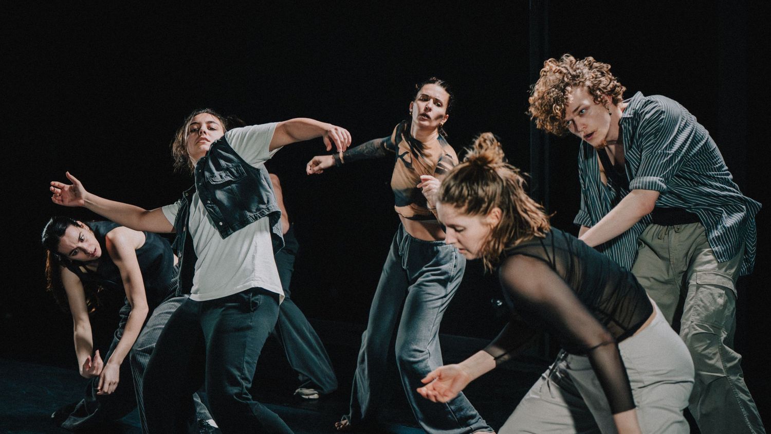 Photo de performance chorégraphique sur scène, danse contemporaine en lumière de spectacle.