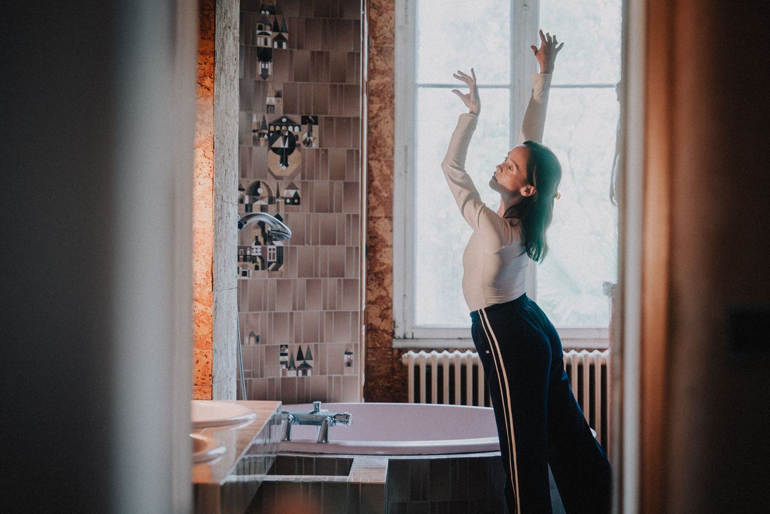 Séance photo artistique en intérieur avec danse contemporaine et lumière naturelle.