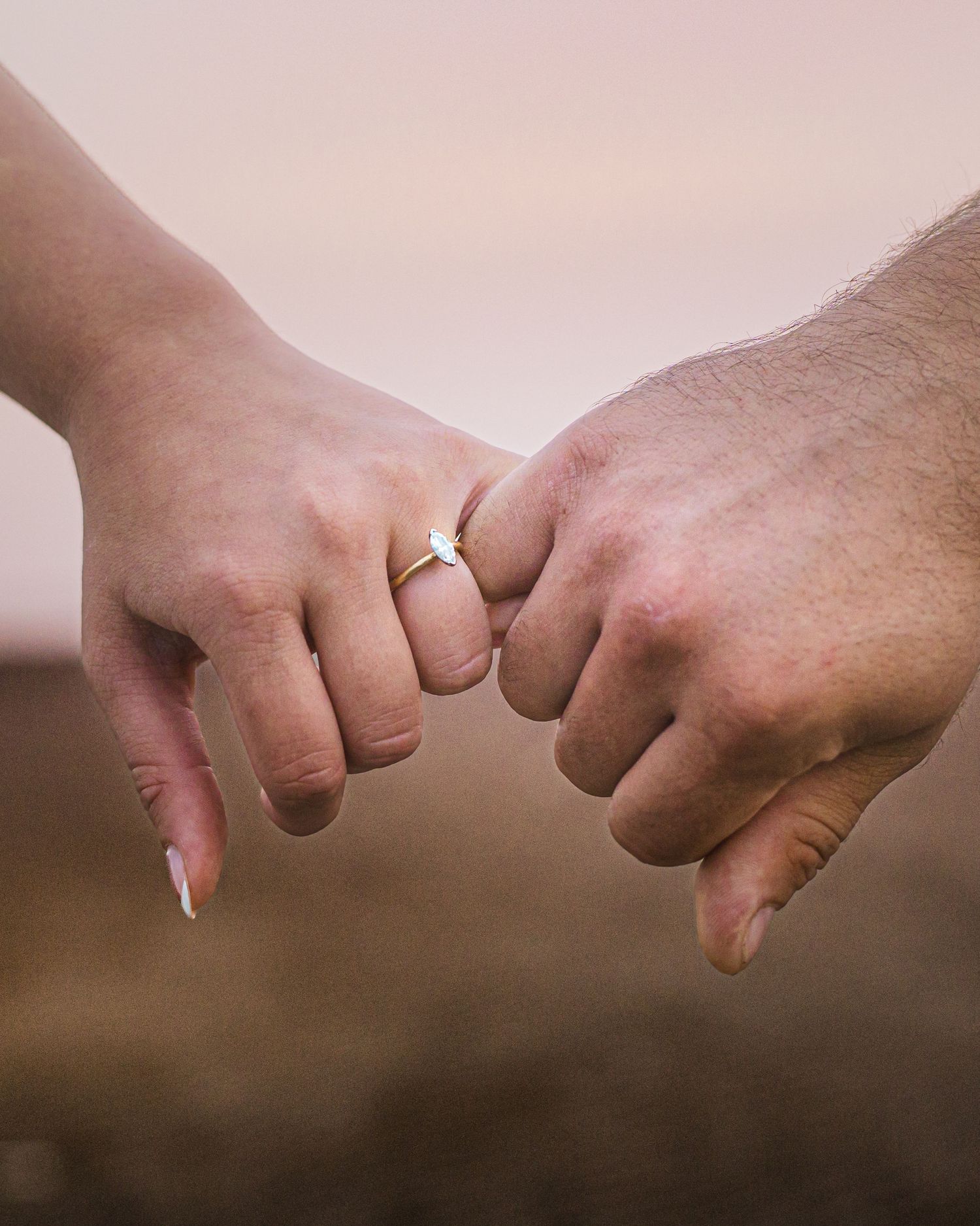 Romantic couple holding hands during a golden hour engagement session in downtown in Moncton, NB.