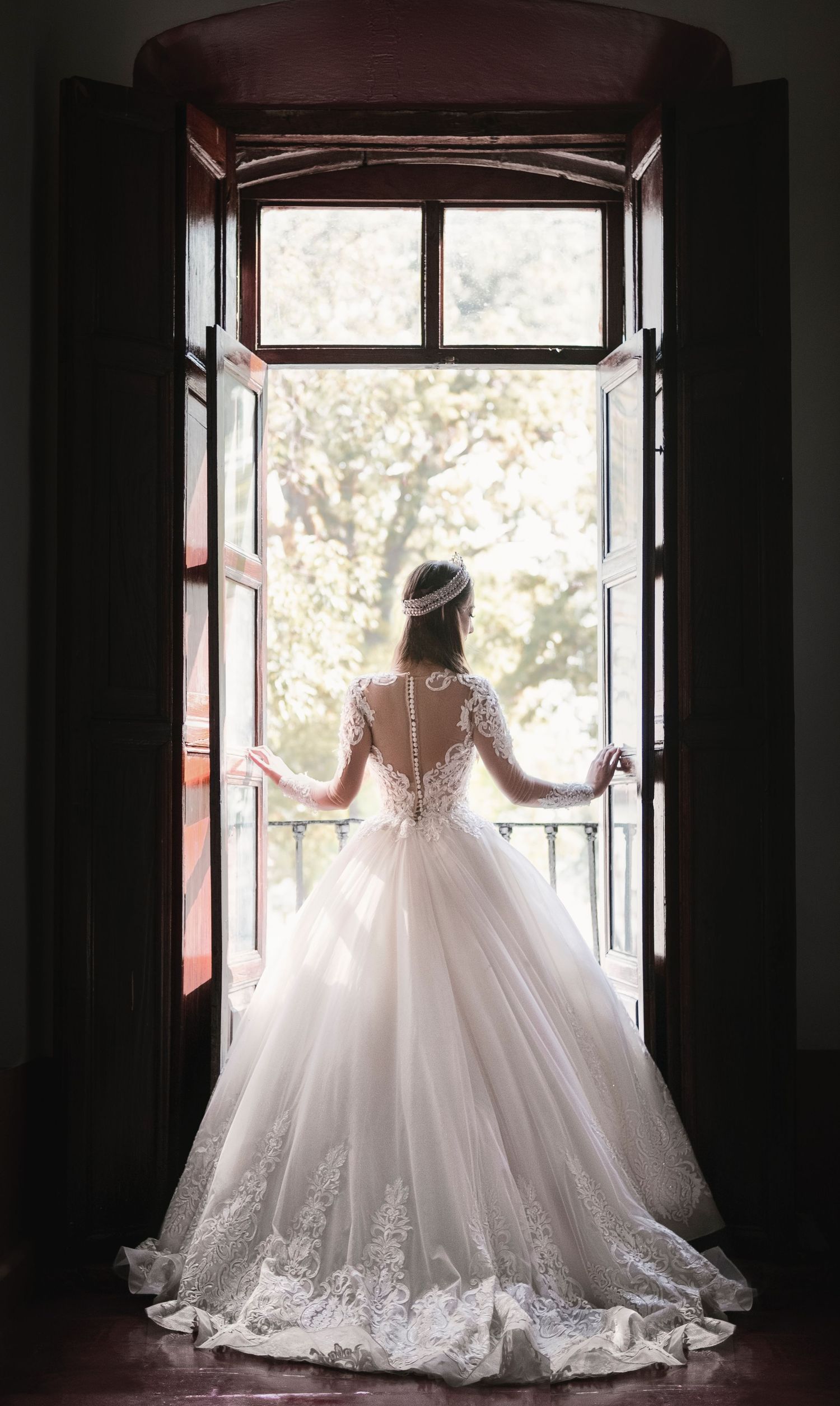 Bride looking outside of the window on wedding day