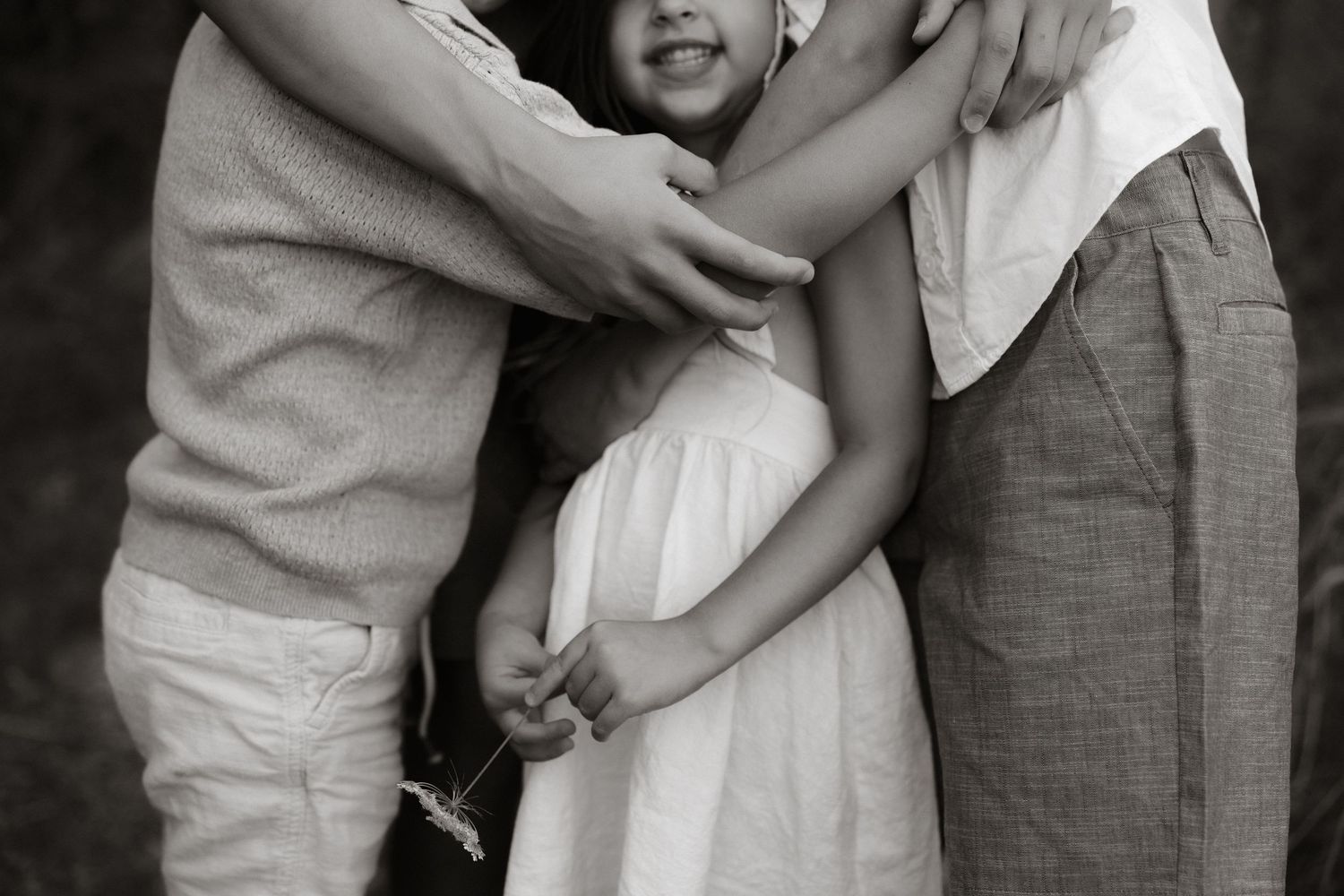 A loving family holding each other in a black and white vintage photo portrait.