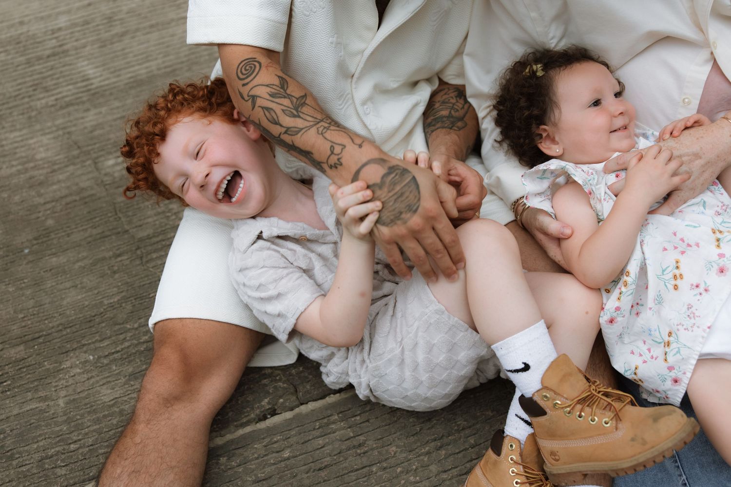 Heartwarming photo series showing multiple tender moments between parents and baby lying on wooden floor.