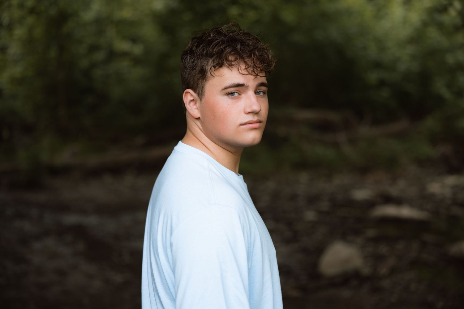 Person in white t-shirt poses in front of dark background in multi-panel photo series.