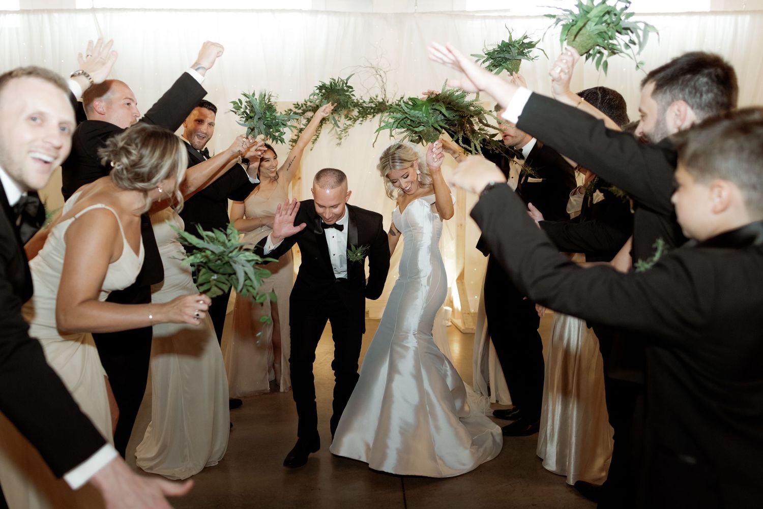 Wedding celebration scene with guests cheering while couple walks through.