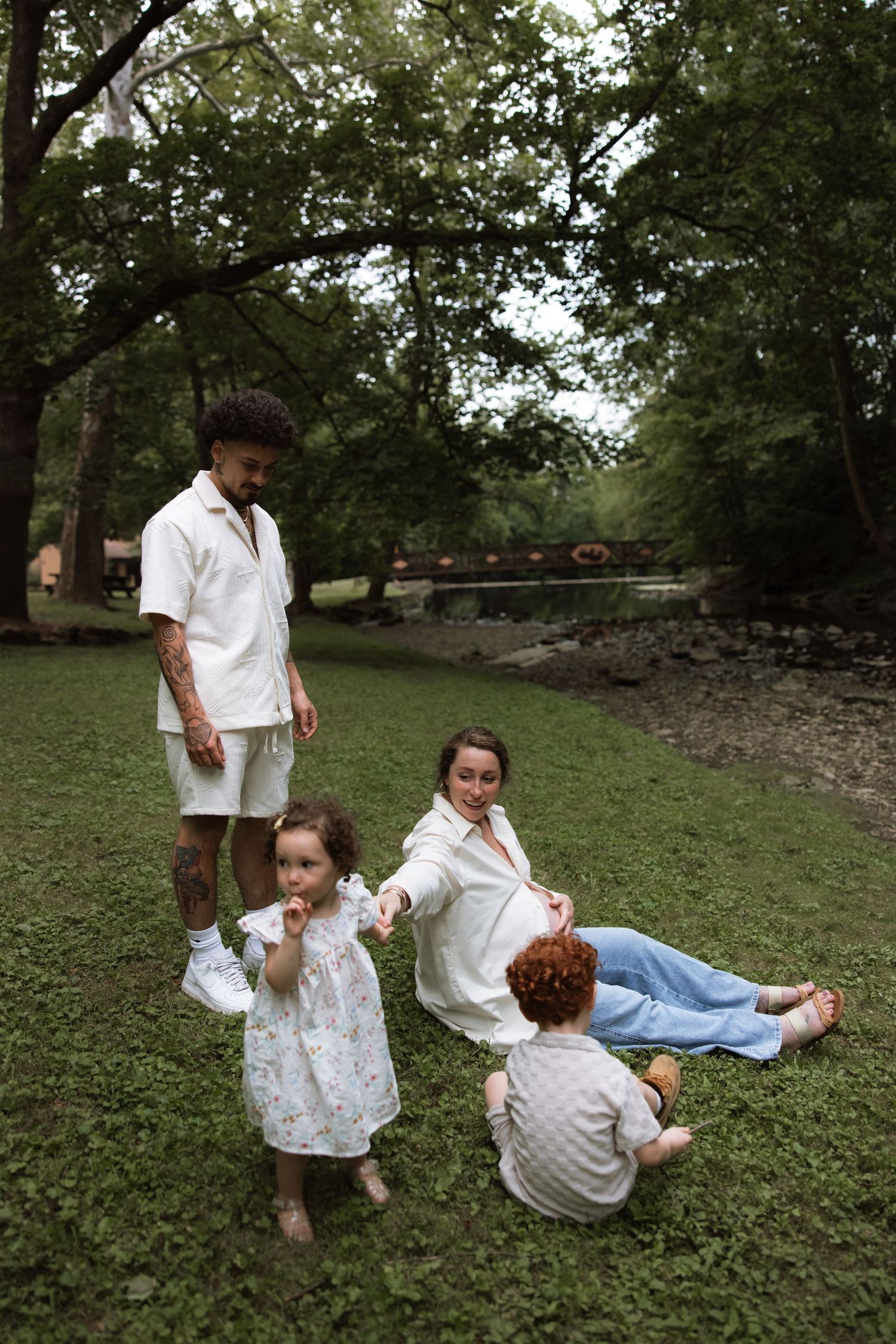 Two people playfully posing in a grassy outdoor setting with trees in the background.