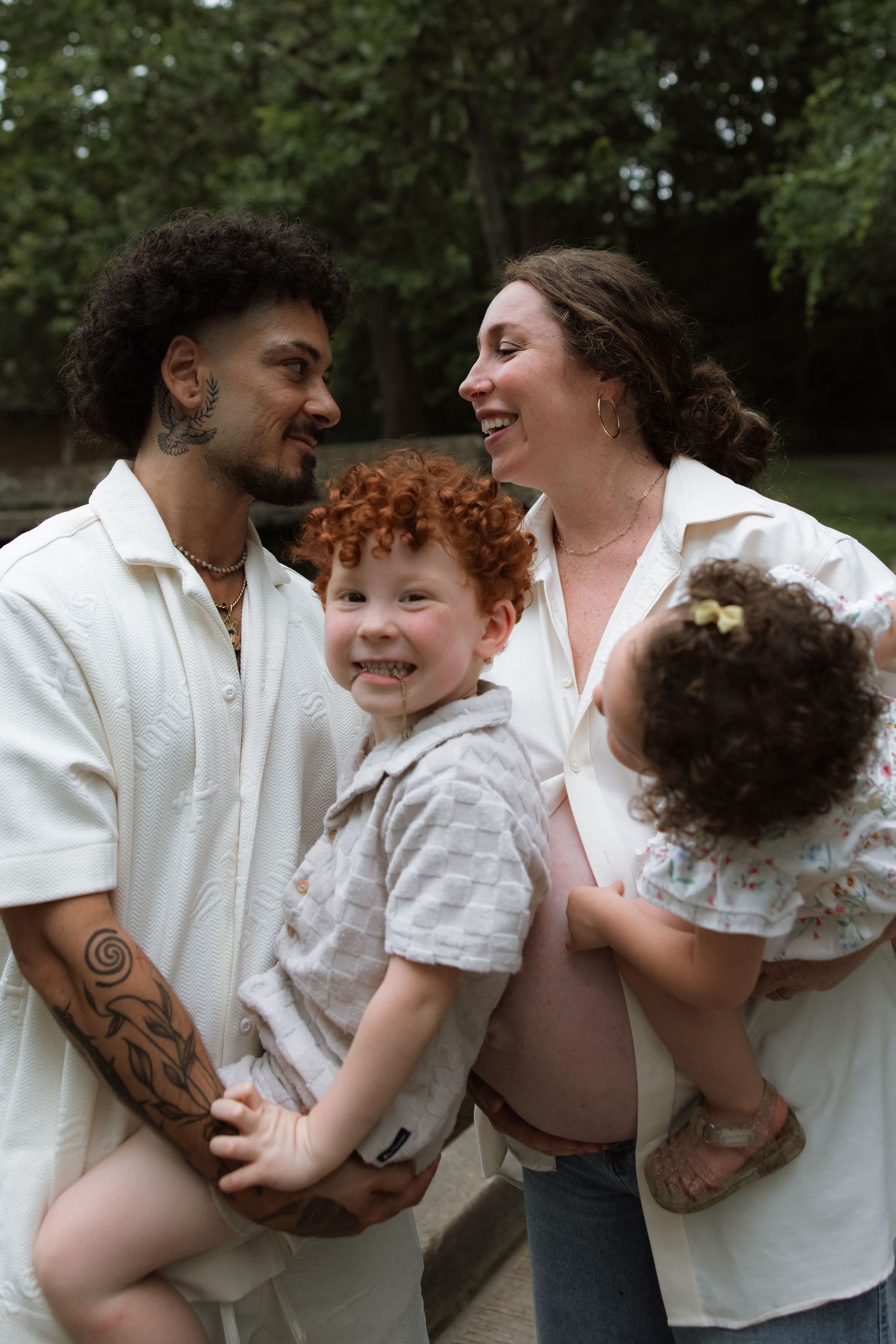 Candid photos show a family sharing playful tender moments together outdoors in matching white outfits.
