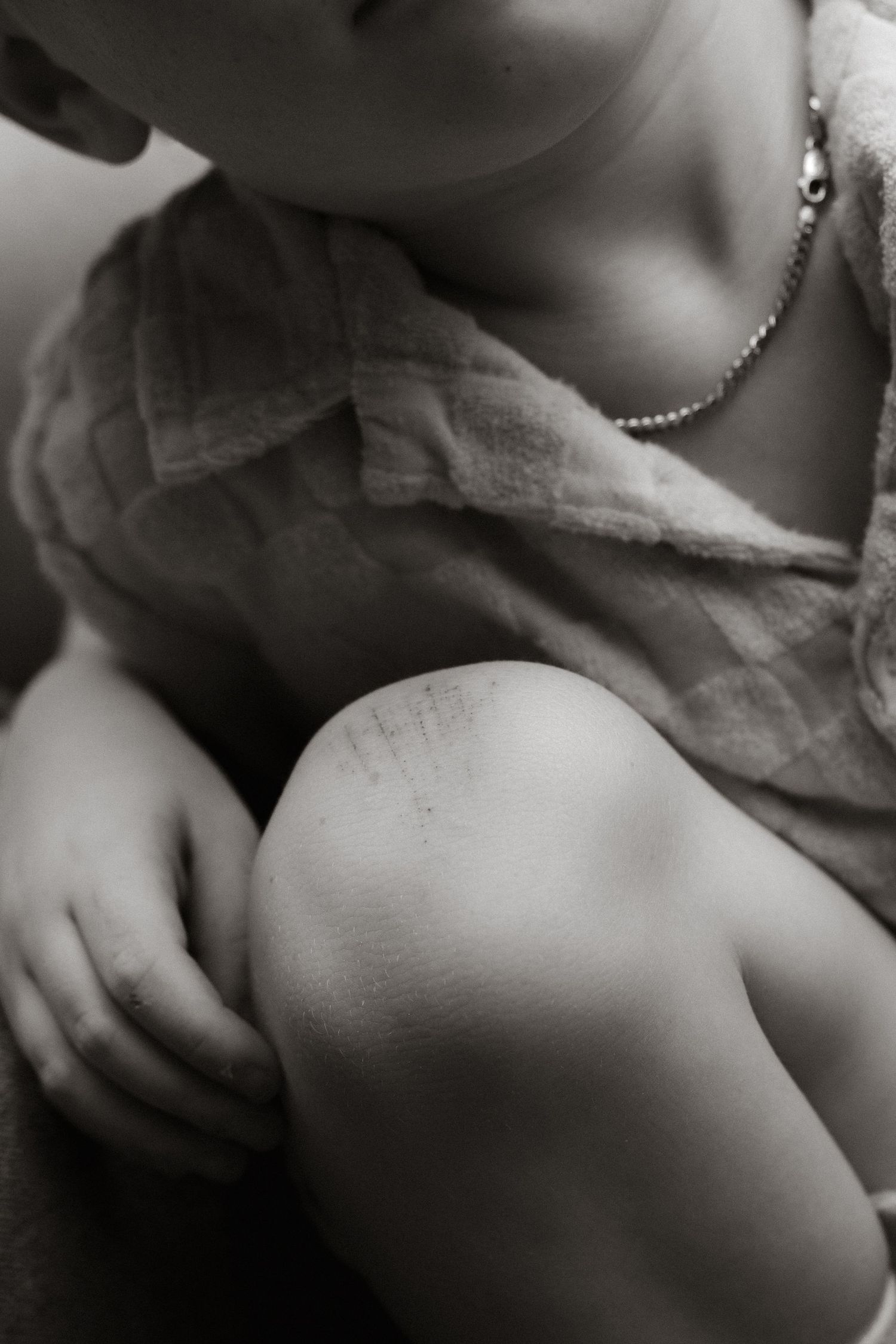 A black and white collage of monochromatic close-up photos showing hands, skin, and limbs in abstract poses.