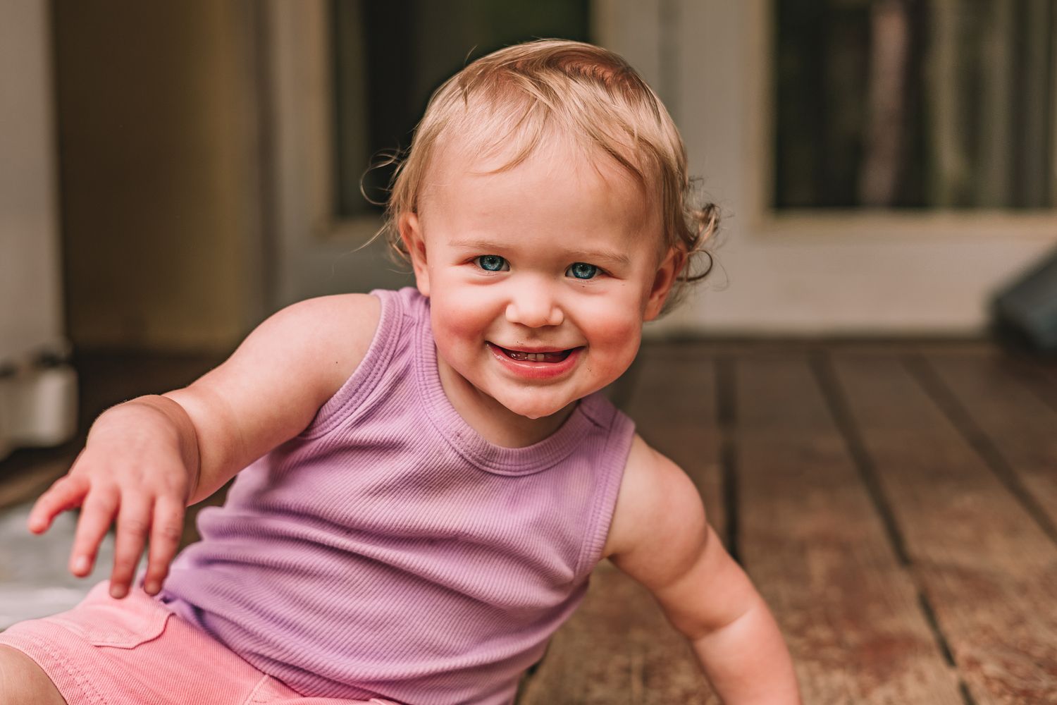 A blonde child in a purple tank top and pink shorts. Photographed by Lost Princess Photography.