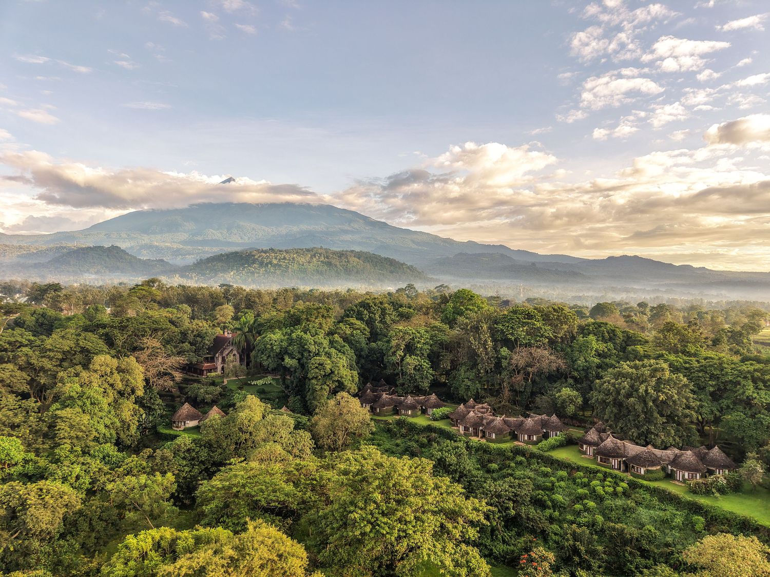 Aerial 8K view of a remote luxury camp; professional Tanzania tourism cinematography and licensed drone services.