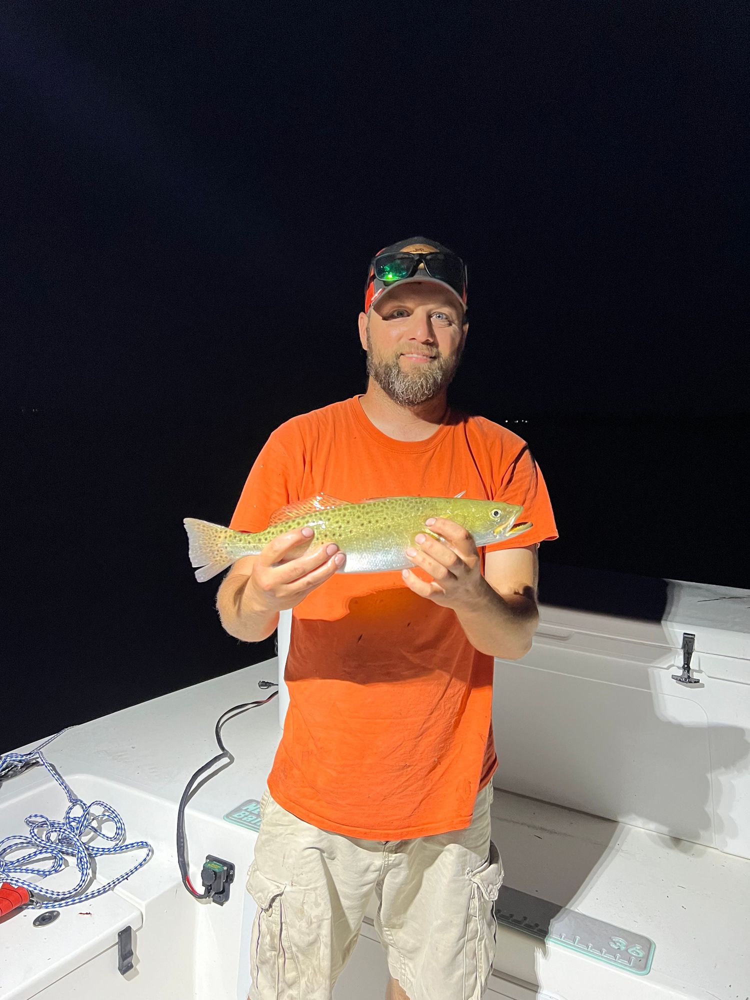 Night fishing trip yields nice trout catch shown on white boat deck.