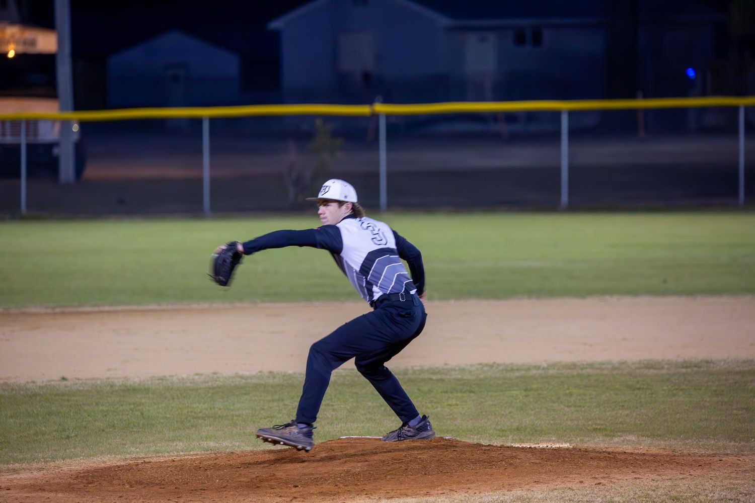Baseball pitcher throwing during intense game action.