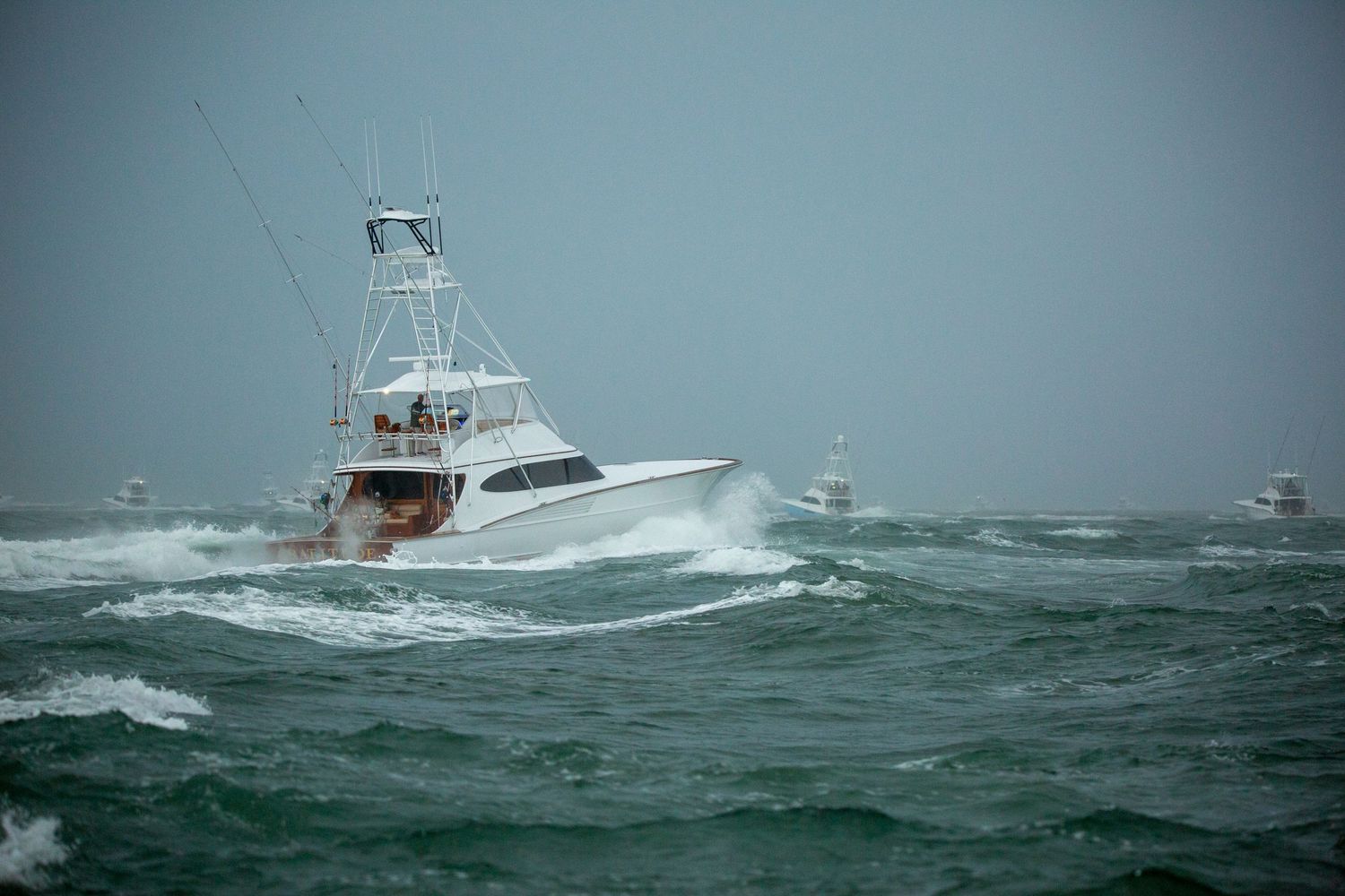 Fishing boat navigates through turbulent seas with waves crashing against hull.