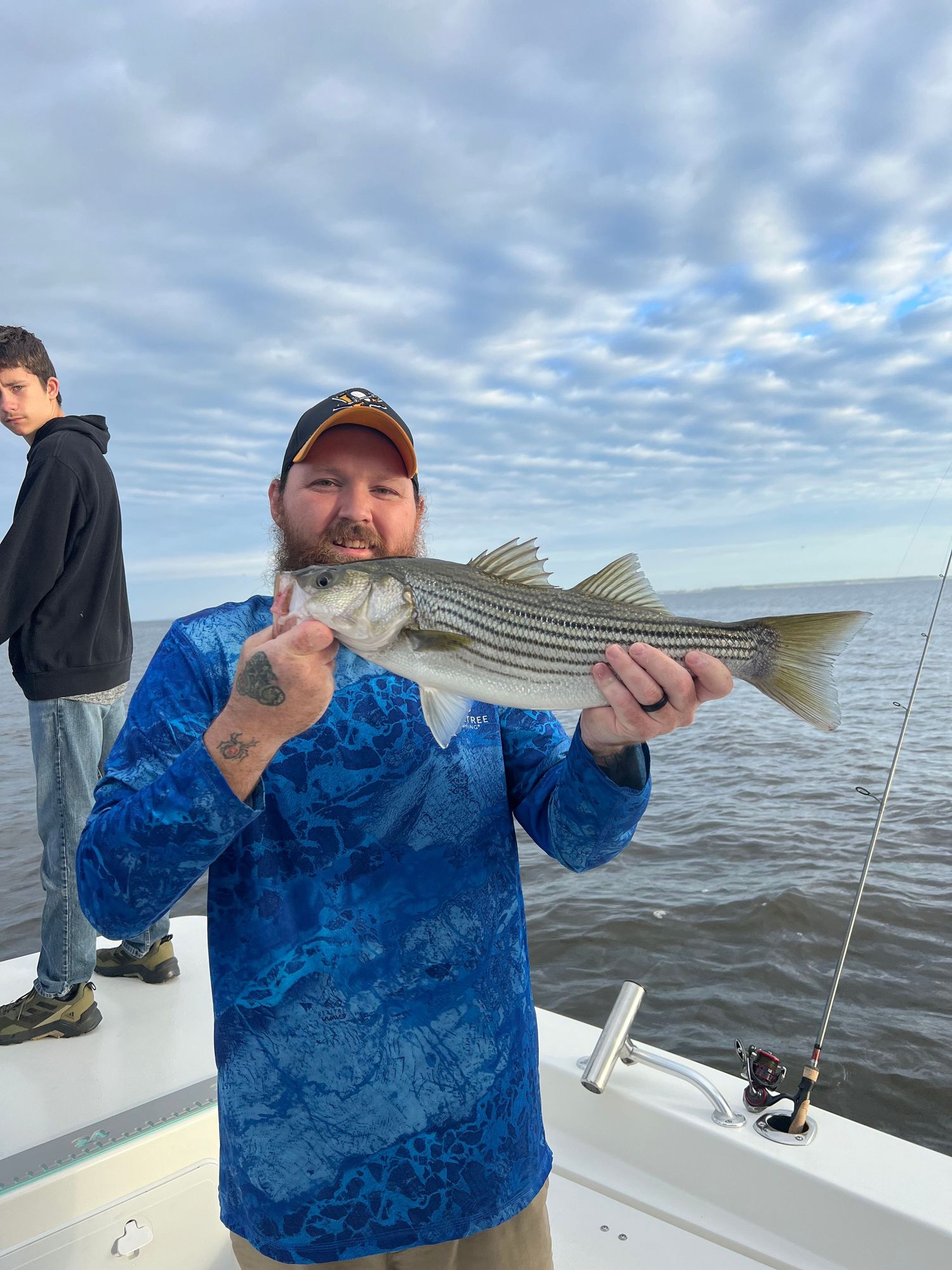 Striped bass caught during daytime fishing trip under cloudy skies.