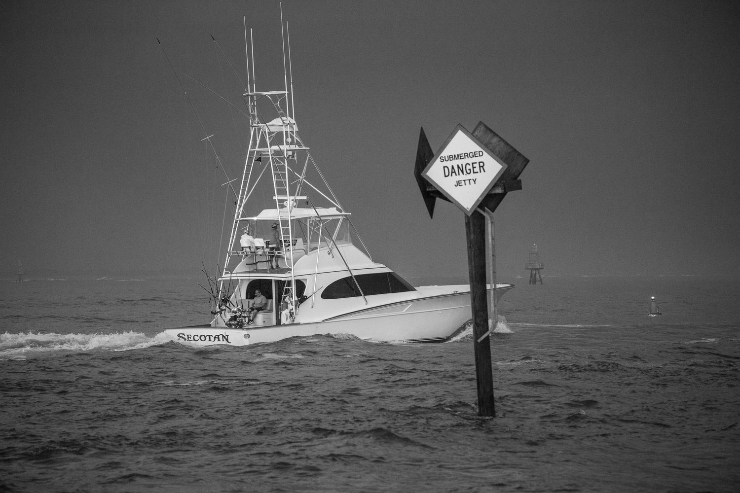 Sport fishing vessel passing by navigation markers in coastal waters.