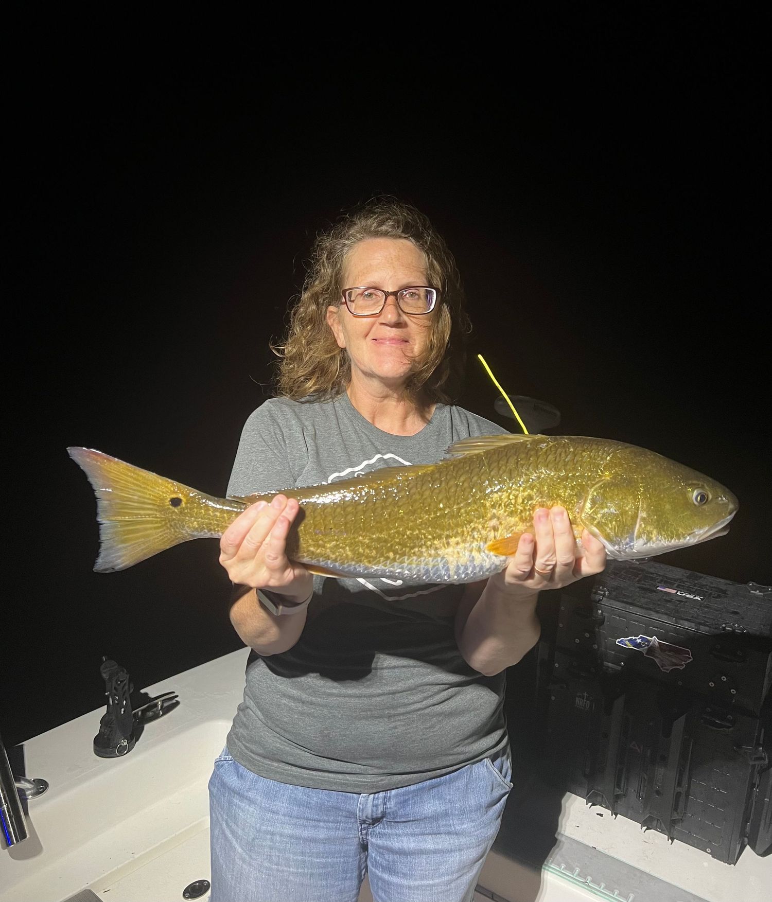 Night fishing success with large golden redfish caught under dark skies.