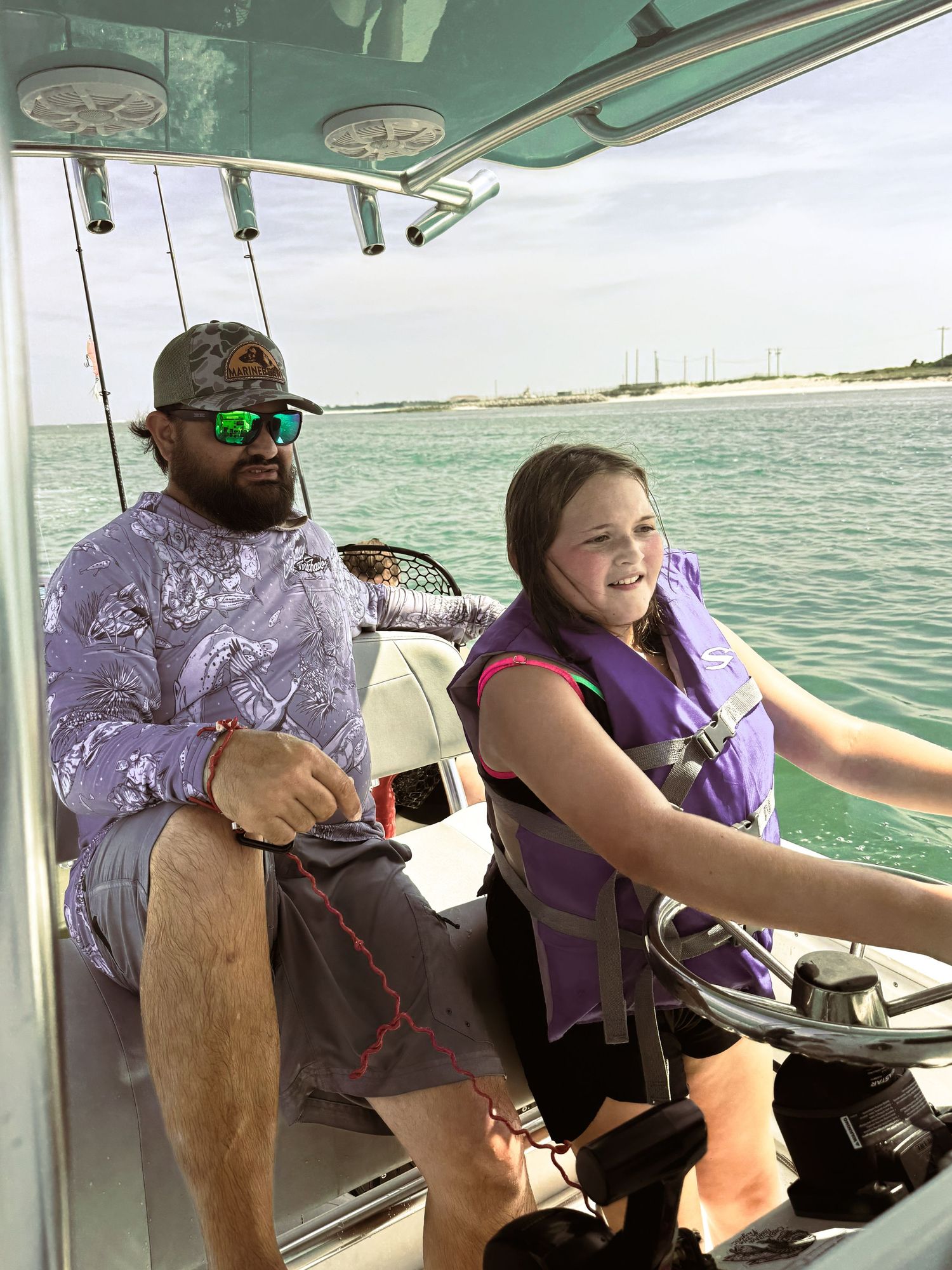 Boating on calm waters with coastal scenery in background during a sunny day.