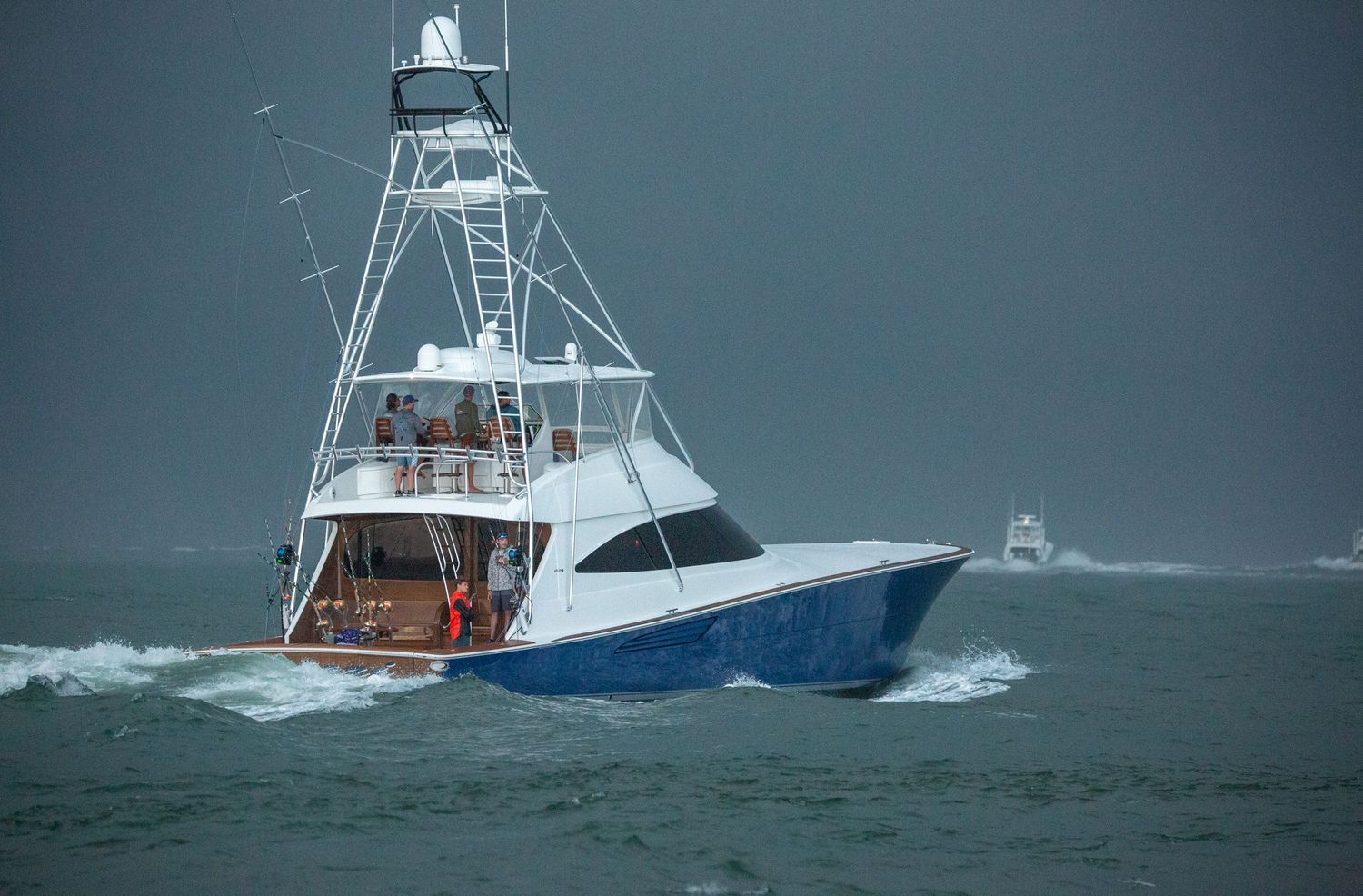 Multiple sport fishing boats navigating through choppy ocean conditions.