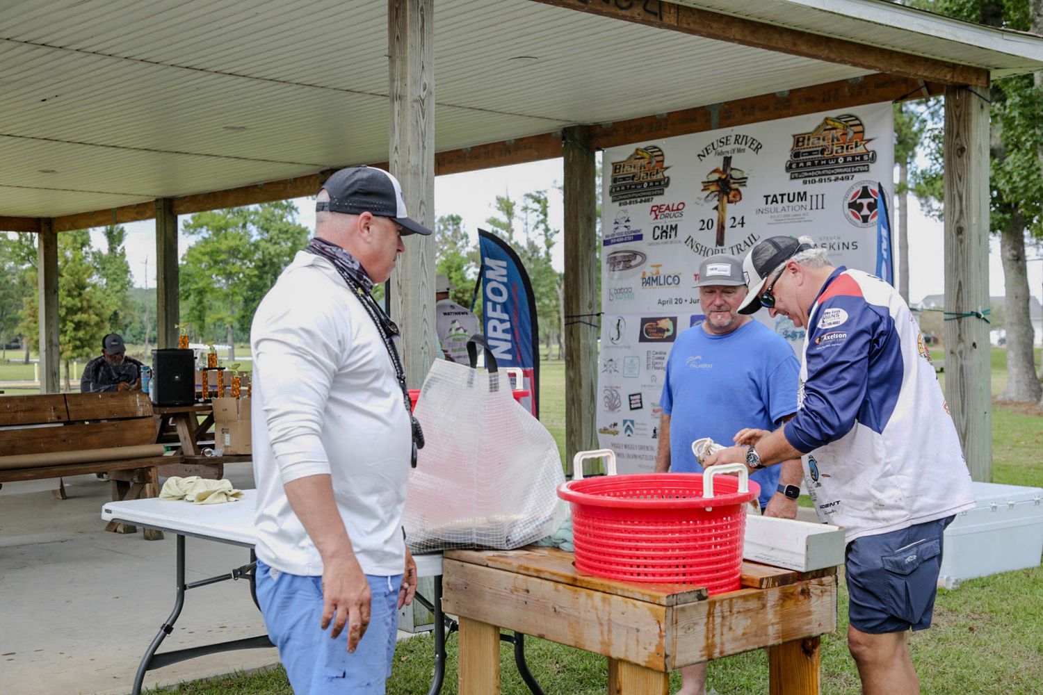 Tournament officials checking in participants at outdoor registration table.