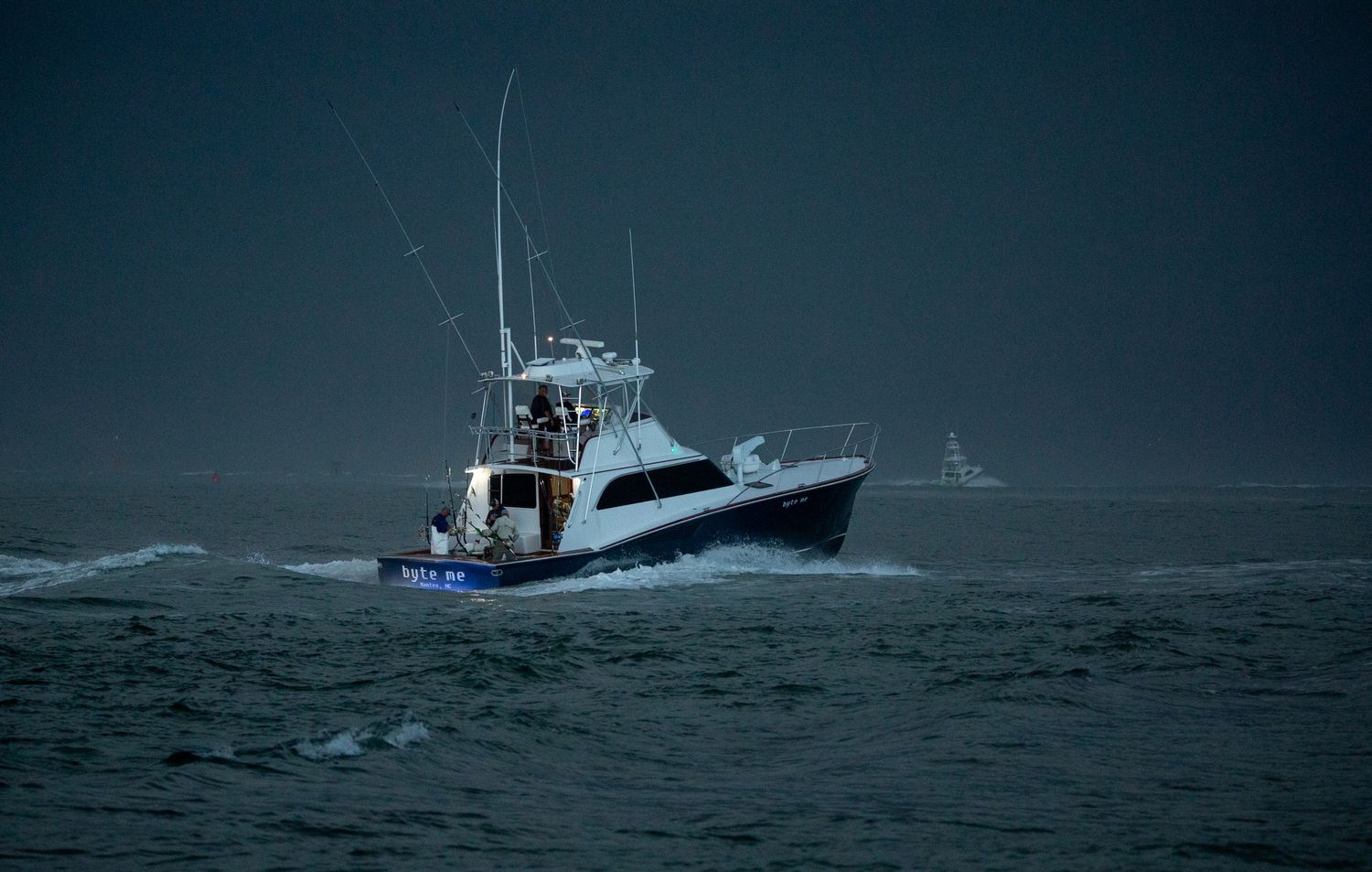 Fishing vessel cutting through dark stormy waters during challenging weather conditions.