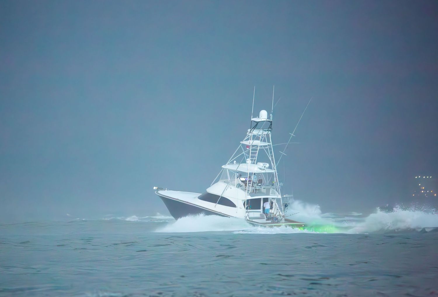 Sport fishing boat navigates through rough ocean waves during stormy weather.