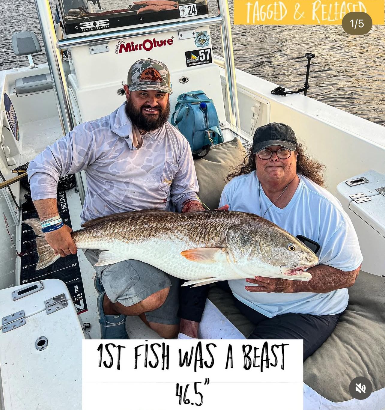 Two anglers proudly display their impressive 46.5 inch redfish catch while seated on a fishing boat at sunset.
